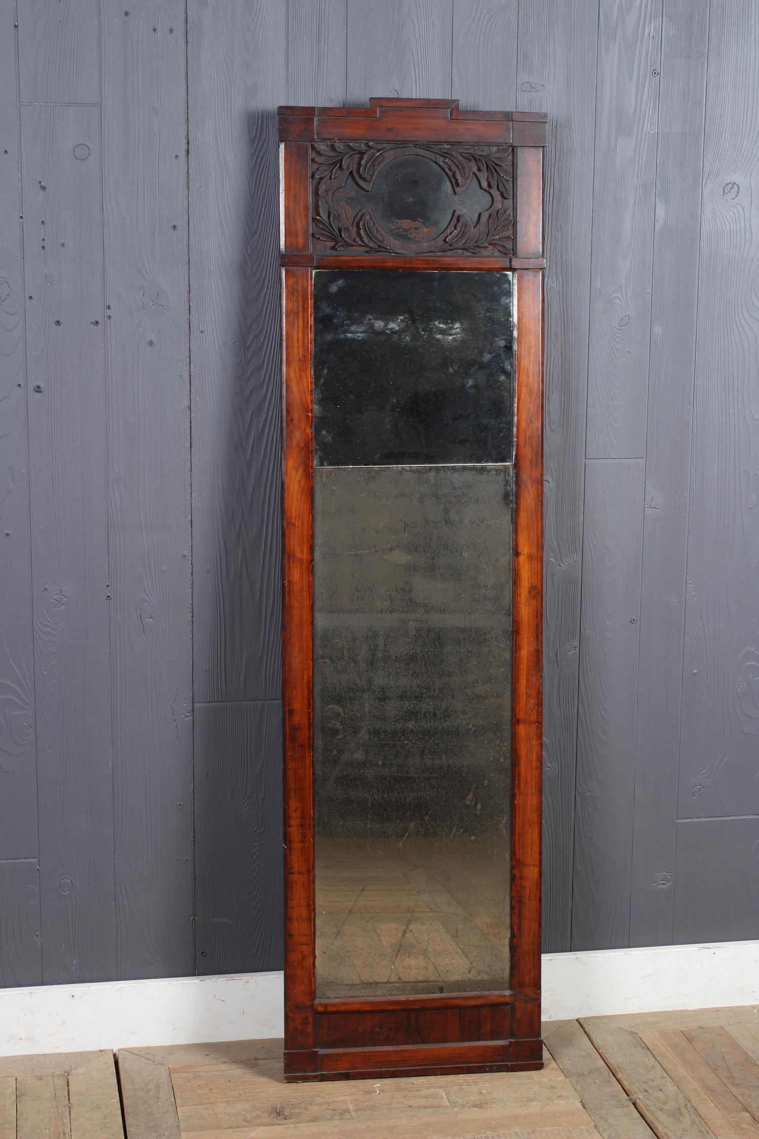 19th C Neoclassical Trumeau Mirror: A 19th C Neoclassical tall vertical mirror having carved leaf form decorated panel above mirrored panels. Size: 59" H x 16" W x 1.5" D