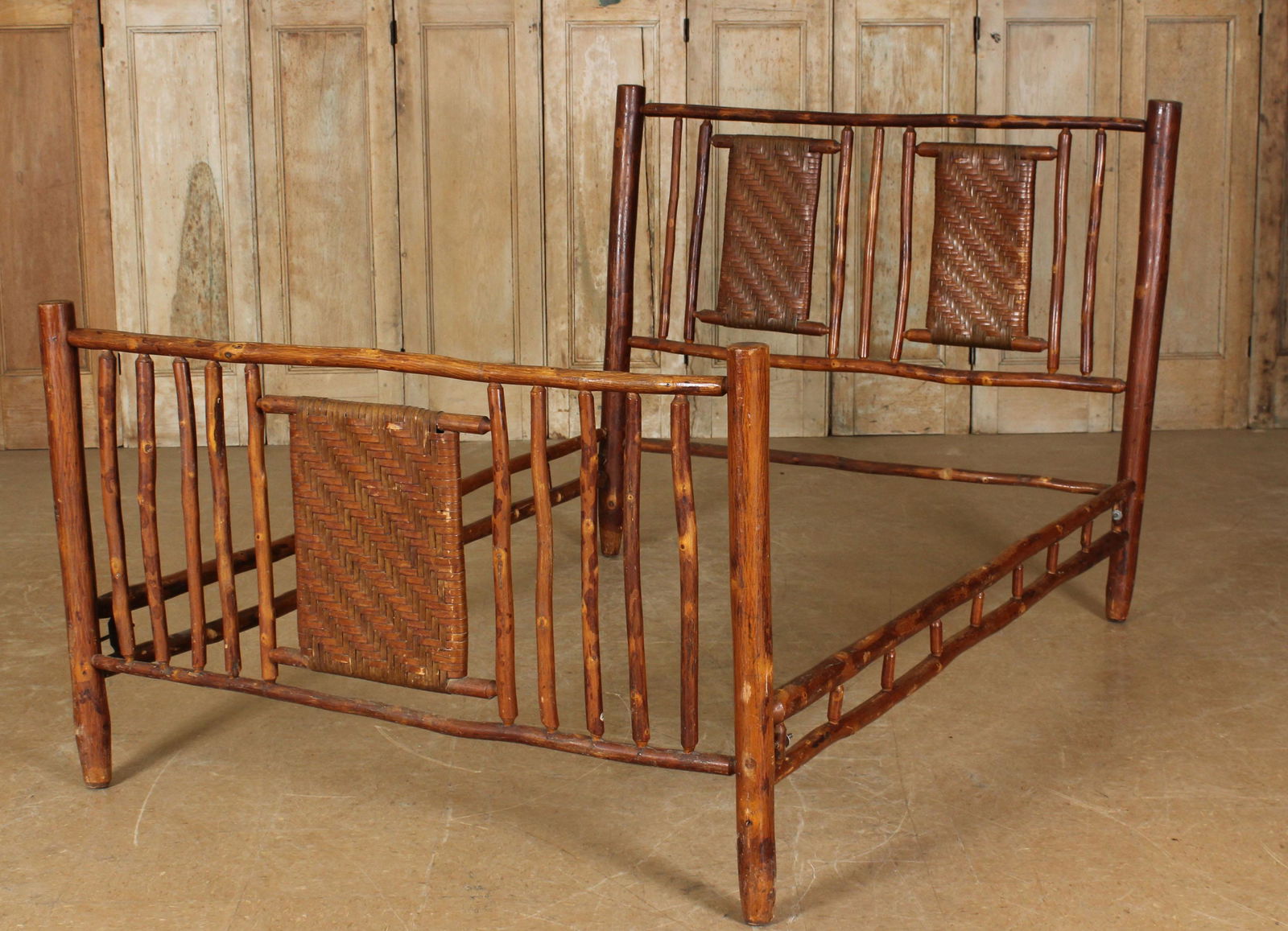 Old Hickory Style Rustic Bed: An Old Hickory style rustic bed having twig spindles and woven panels. Size: 48" H x 58" W x 73" D