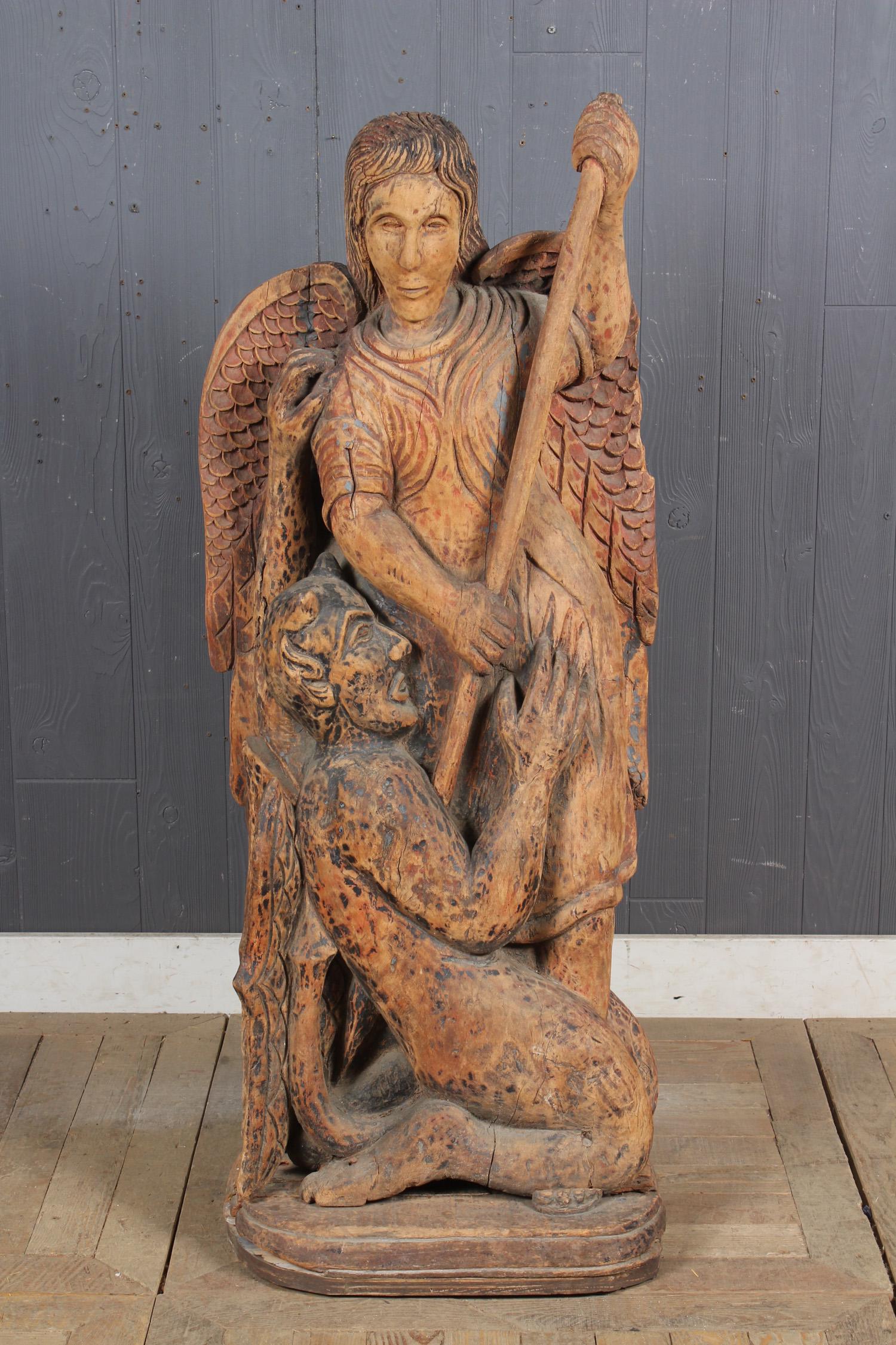 Wood Carved St Michael Slaying Lucifer: Interesting late 19th century large scale carved wood and paint decorated sculpture/ Santos figure representing St. Michael slaying Lucifer. 48" H x 20.5" W x 12.5" D