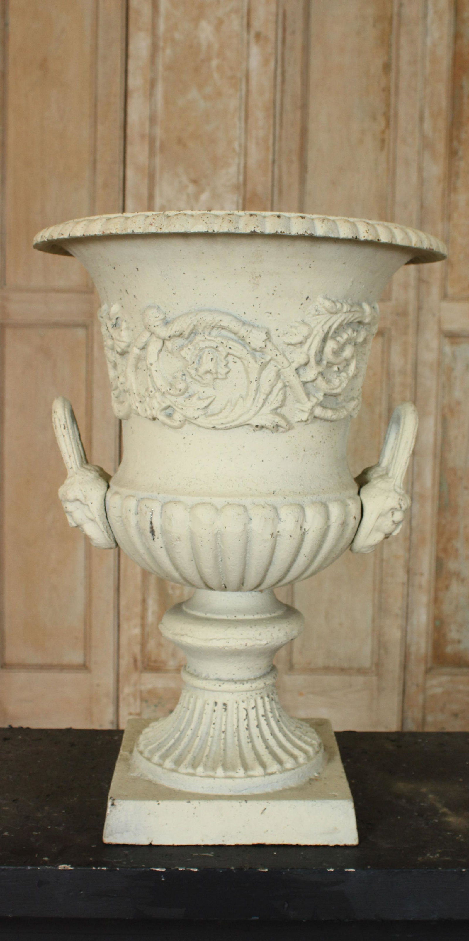 White Painted Cast Iron Urn: White Painted Cast Iron Urn, campana form, foliate decoration, double handled, mask loop decoration. Size: 24.25" H x 17" Diameter