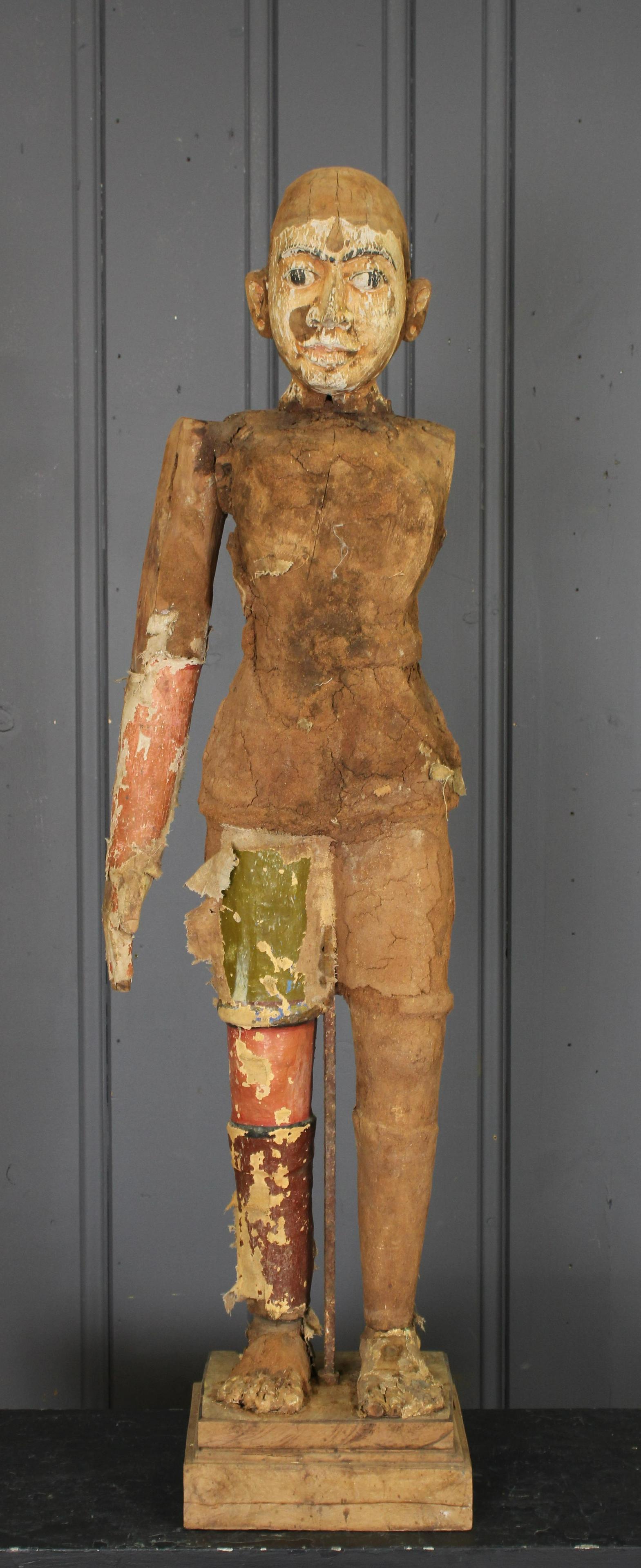 Figural Indian Regimental Guard: Late 19th century Colonial carved wood textile and formed mud guardian figure, with painted face and remnants of regimental uniform. Size: 49.5"H on 10" x 10.5" base