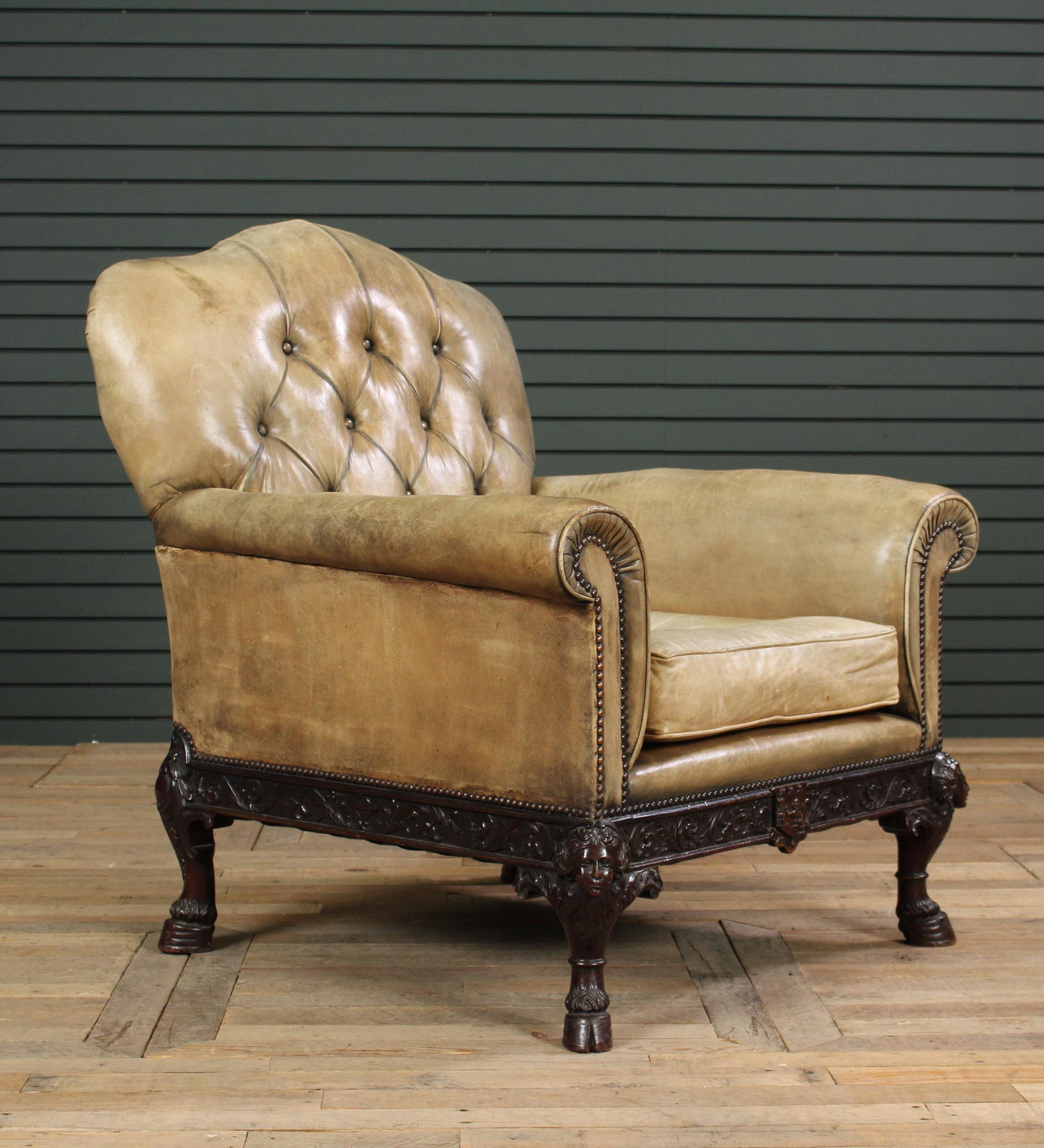 English Leather Upholstered Library Chair: English Leather Upholstered Library Chair having tufted back over loose cushion seat, all raised on carved cabriole legs with hoof feet. Size: 41" H x 37" W x 33" D.