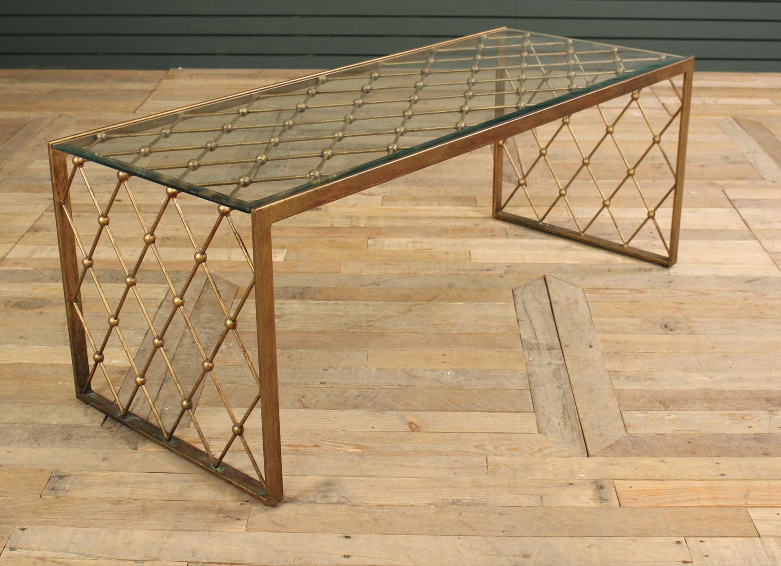 Jean Royere Style Gilt Wrought Iron Coffee Table: Jean Royere Style Gilt Decorated Wrought Iron Coffee Table with ball and trellis design, beveled glass top. Size: 19.5" H x 51" W x 20" D.