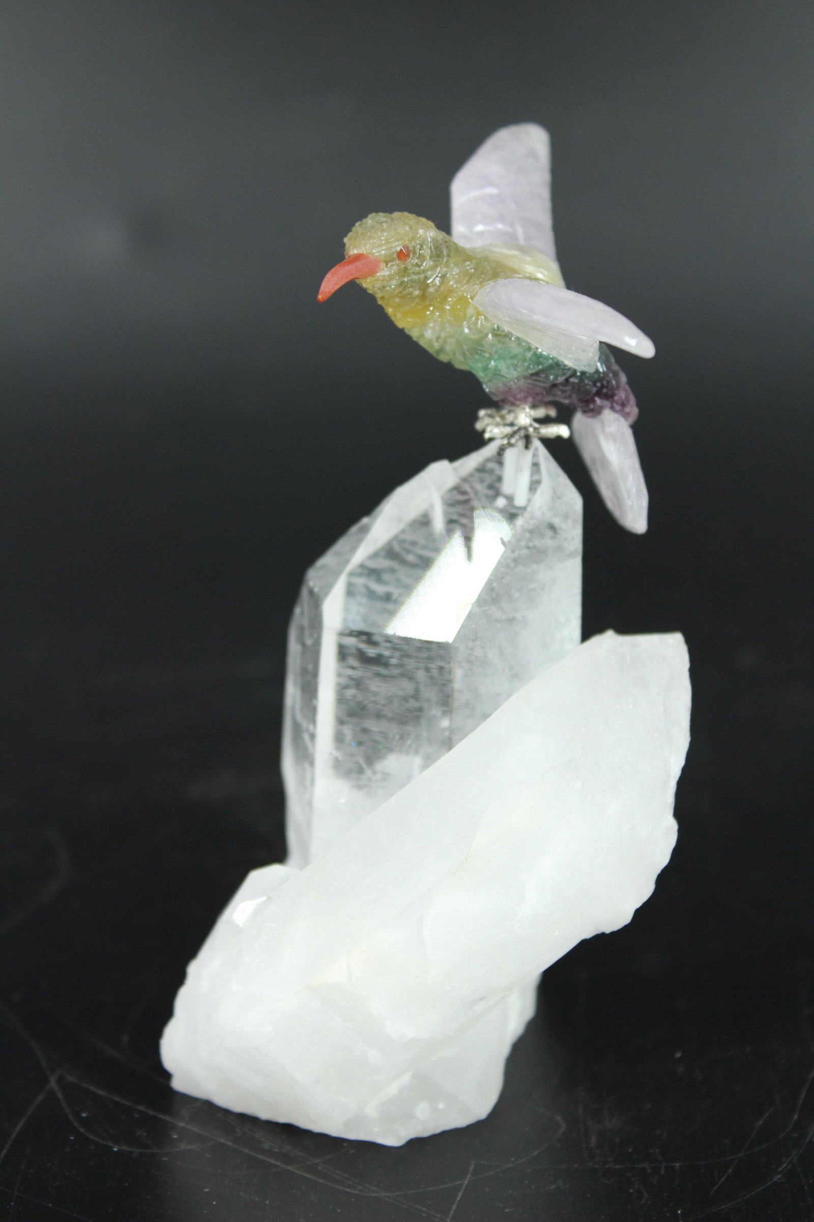 Terminated Quartz Crystal Figural Group: Carved Polychrome Hardstone Bird on Rock Sculpture. Bird with spread wings, silver plated feet mounted on quartz base. Size: 5"H x 3.5"W x 2.5"D