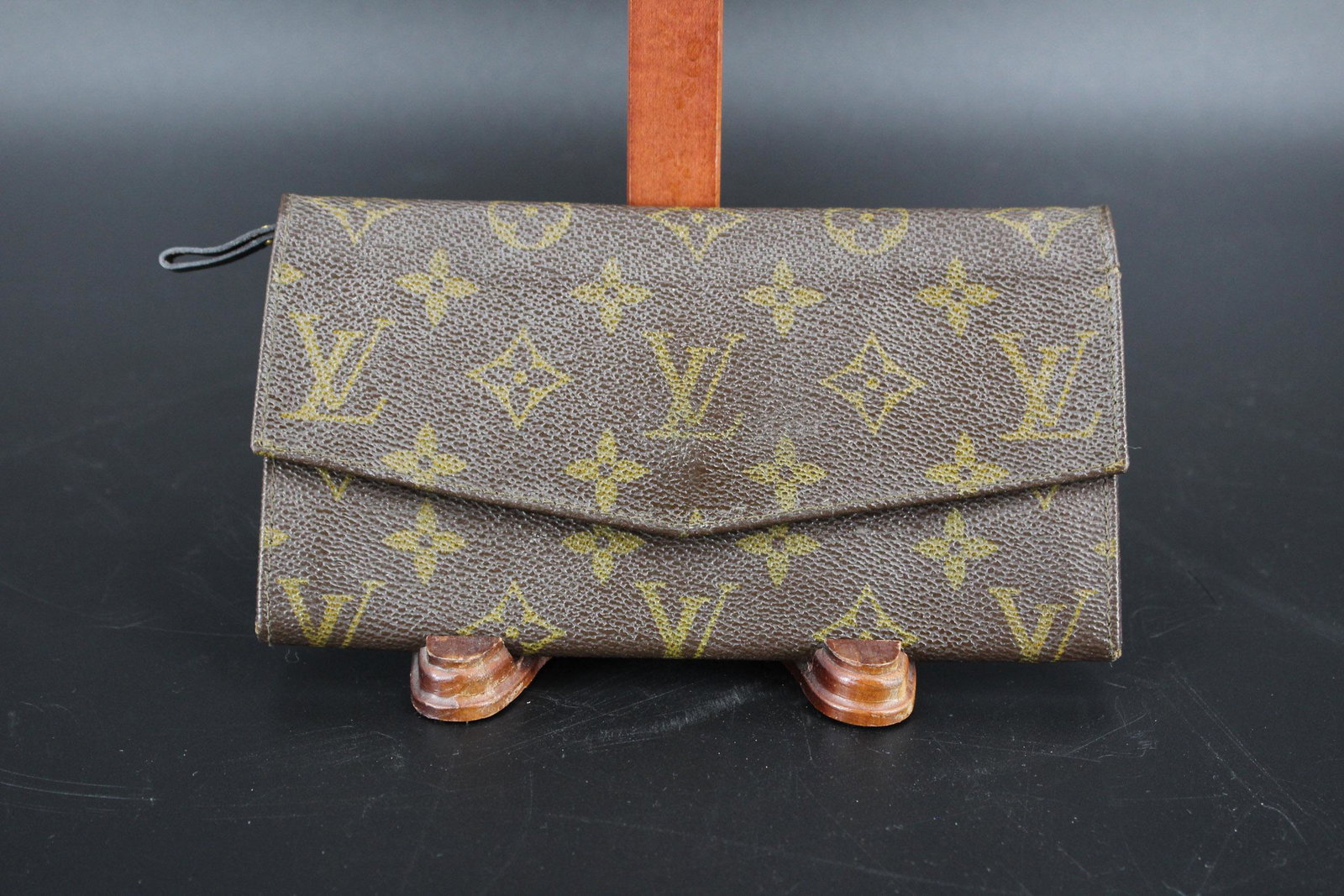 Louis Vuitton Monogrammed Canvas Leather Clutch: Louis Vuitton Monogrammed Canvas Leather Clutch, bi-fold wallet with center zipper closure. Size: 4" H x 7.25" W x 0.75" D.