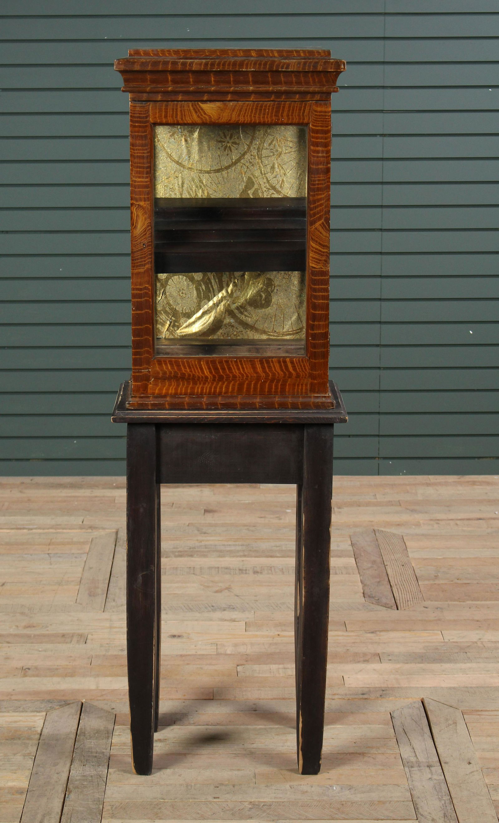 Turn of the Century/ Early 20th C Display Cabinet: Turn of the Century to Early 20th C Display Cabinet, having faux paint decorated exterior and retro fitted interior now supported on contemporary base. Size: 57" H x 17" W x 12.5" D.