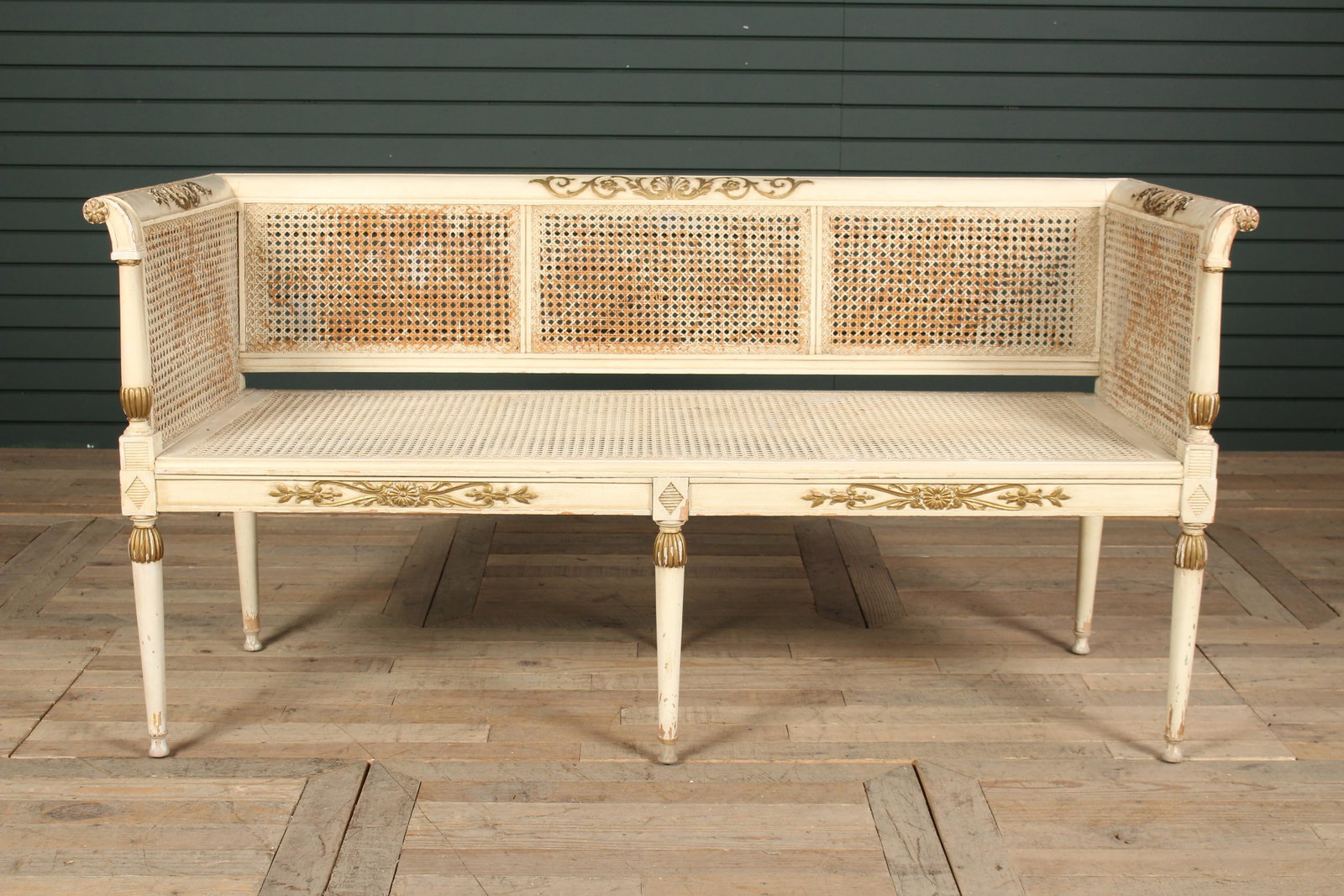 French Directoire Style Settee: French Directoire Style Settee, carved and paint decorated, having caned back and seat framed by turned posts and raised on turned legs, cushion available. Size: 30.5" H x 59" W x 23.5" D.