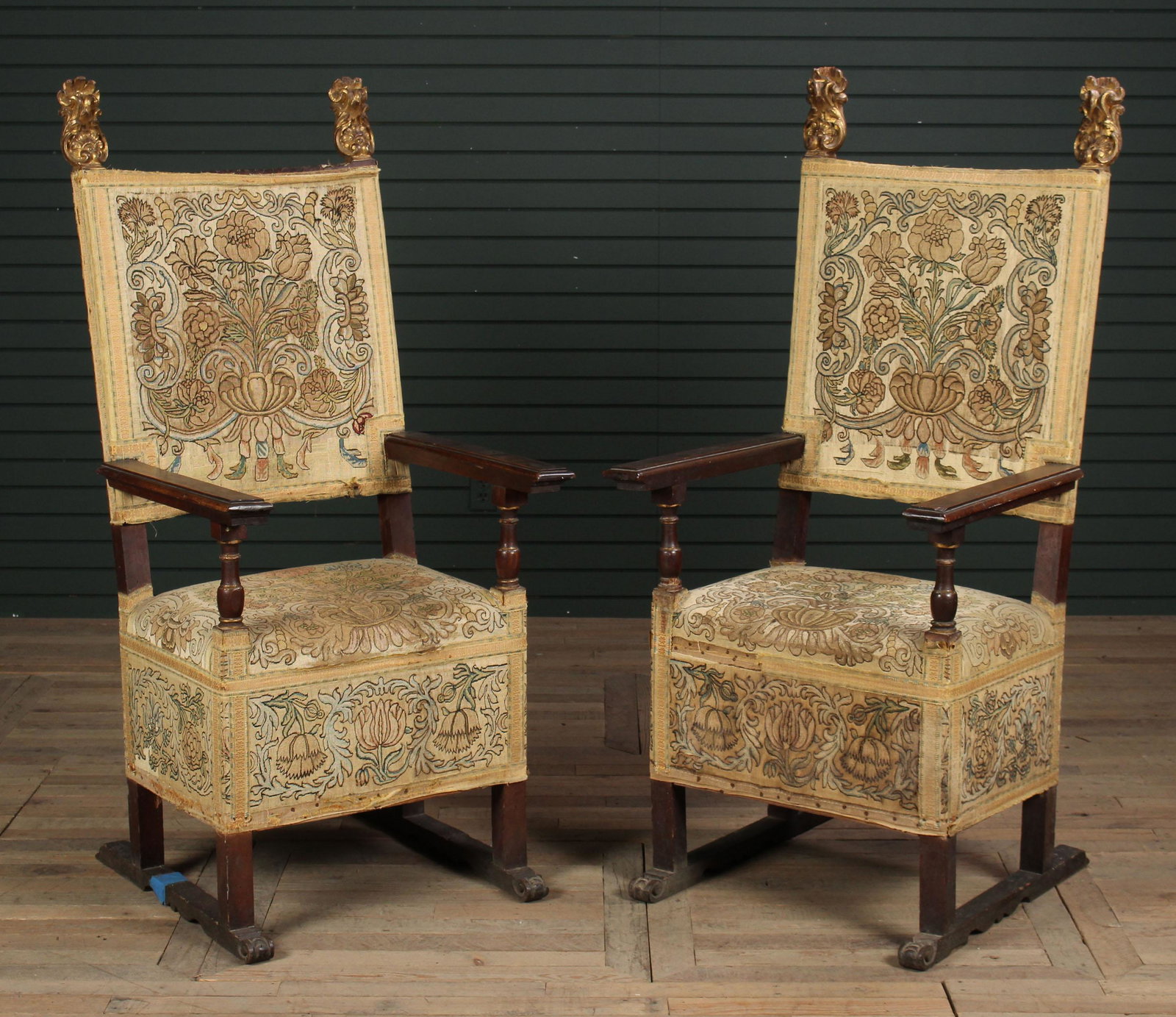 Pair Antique Italian Carved Walnut Armchairs: Pair Antique Italian Carved Walnut Armchairs, possibly 18th C., having giltwood carved finials and open arms framing decorated seat, all raised on carved base. Size: 59" H x 27" W x 28" D.