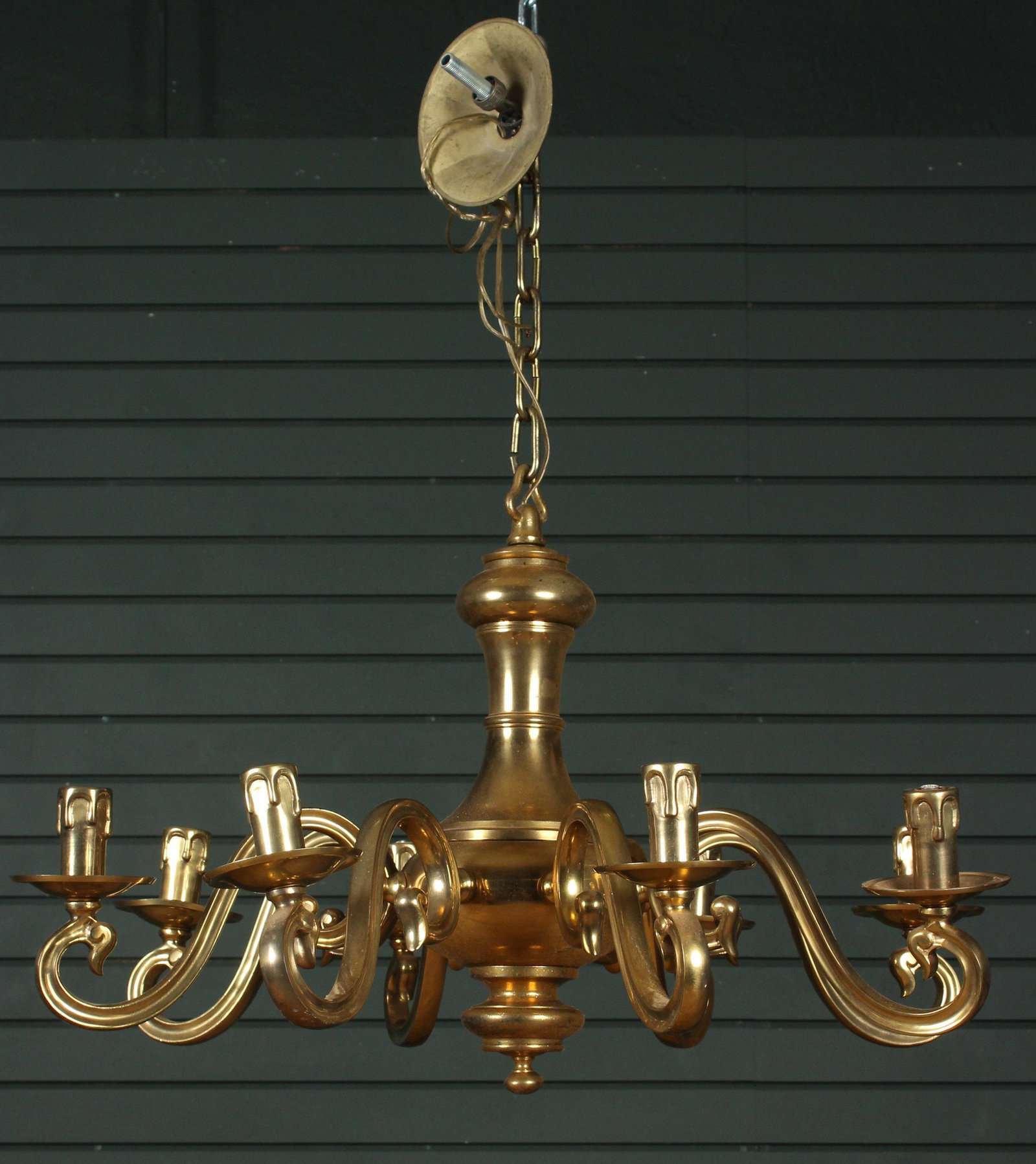 Heavy Cast Bronze Chandelier: A bronze chandelier having eight scrolled arms supporting unusual bronze faux candle sockets. Size: 18.5" H x 29" W x 29" D