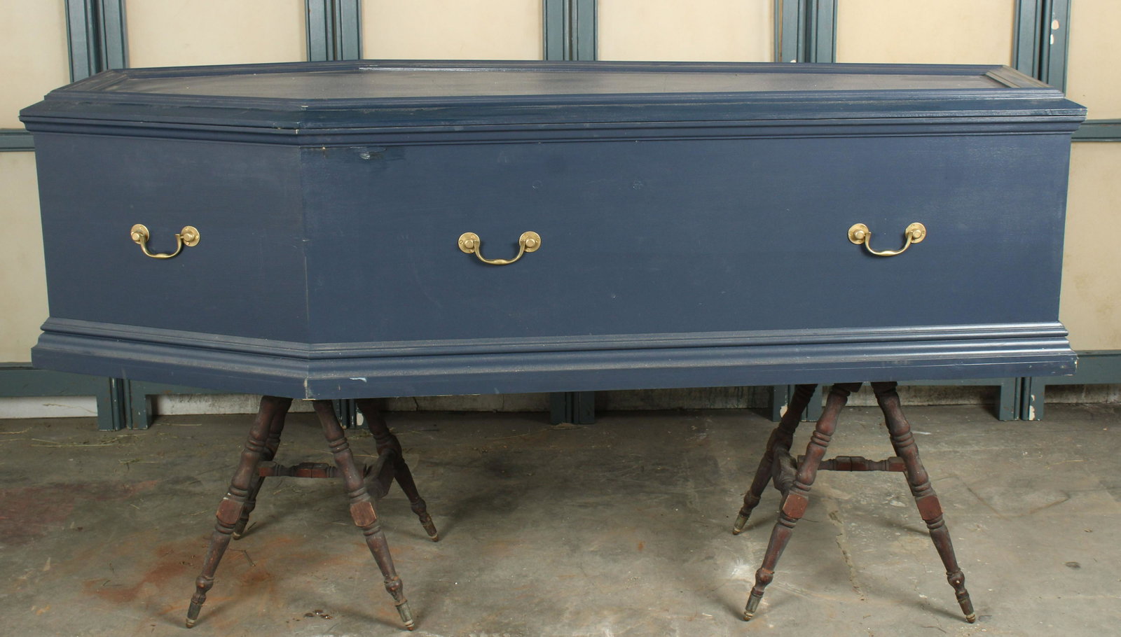 Satin Lined Coffin with Folding Biers: A painted coffin with brass handles and satin lining with a pair of folding stands. Studio made. Size: 43.5" H x 81" W x 31" D Provenance: Production of â€œDickinson”