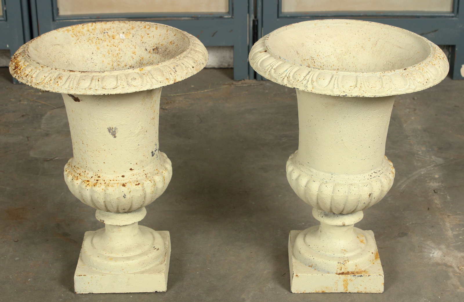 Pair Cast Iron Campana Garden Urns: A pair of white painted cast iron Campana urns having an egg and dart decorated rim. Size: 18" H x 13.5" W x 13.5" D