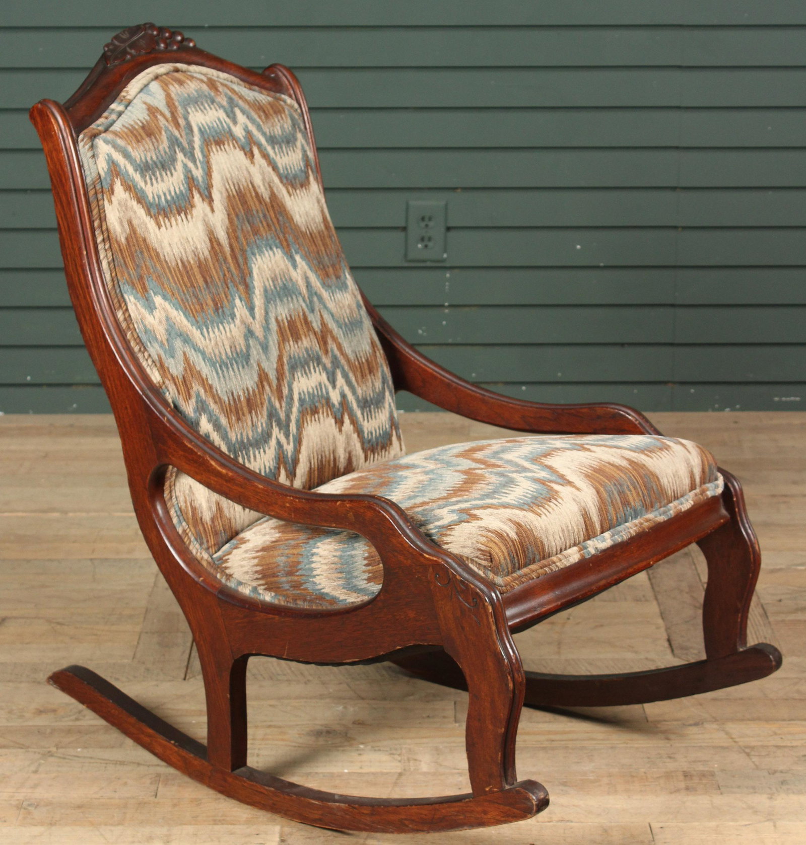 Victorian Carved Rocker: A Victorian rocking chair having a carved crest and incised details down the arms and sides. Size: 36" H x 21" W x 32" D Provenance: Production of â€œDickinson”