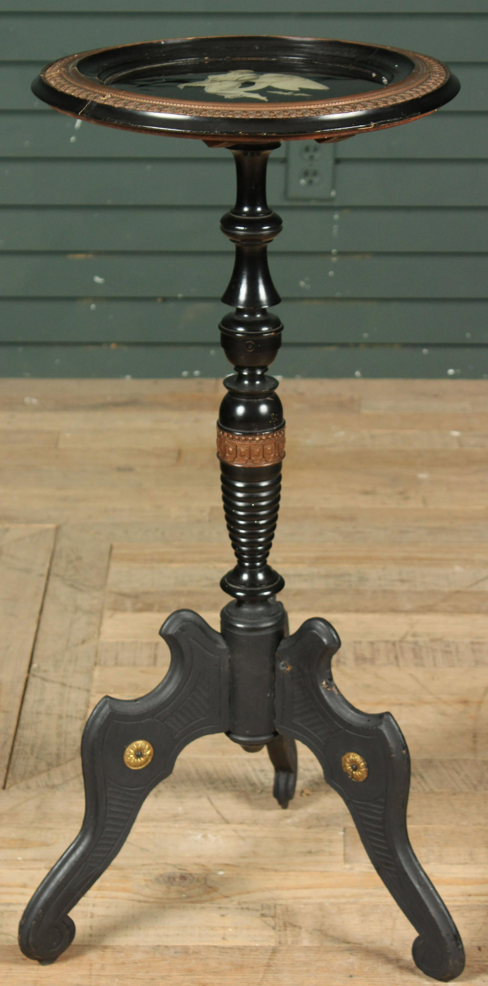 Ebonized Aesthetic Picture Top Stand: An ebonized Aesthetic Movement stand having an inset glass top depicting an angel above a turned column resting on shaped and incised feet. Size: 33.5" H x 17" W x 16" D Provenance: Production of â��