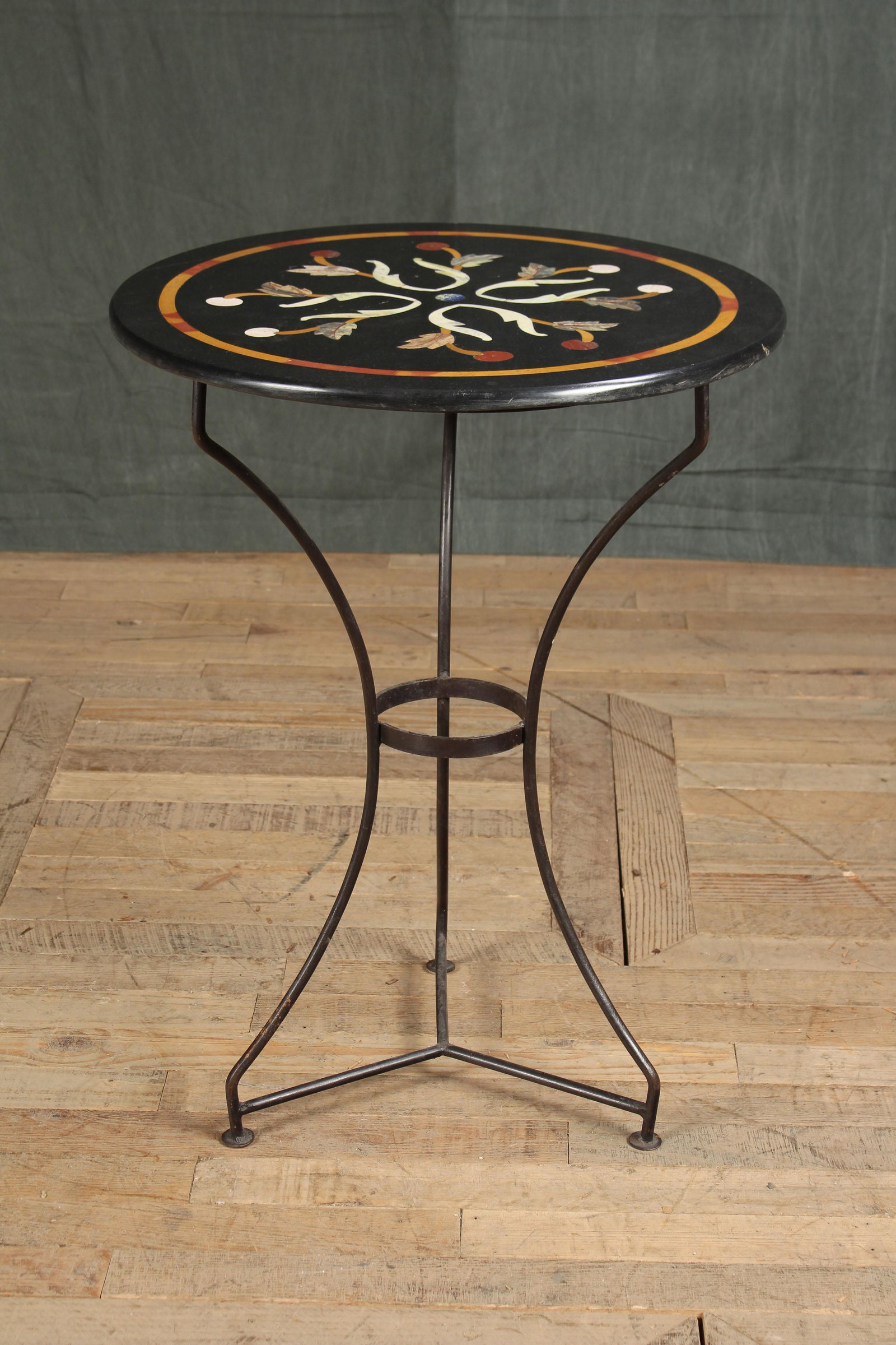 Italian Mantici Style Pietra Dura Gueridon: A good Italian Mantici Style pietra dura marble inlaid gueridon having stylized foliate and vine designs all resting on wrought iron base. Size: 31"H x 23'Dia.