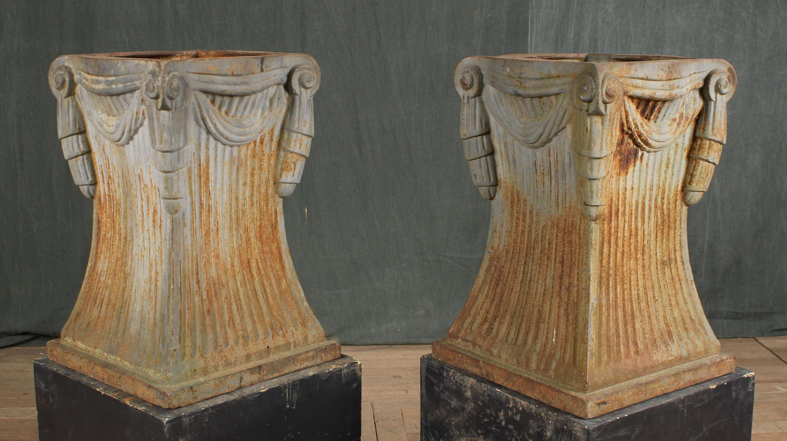Pair Cast Iron Neoclassical Style Pedestals: A pair of Neoclassical cast iron pedestals each having tassel and draped cord decoration. Size: 21"H x 14"W x 14"D