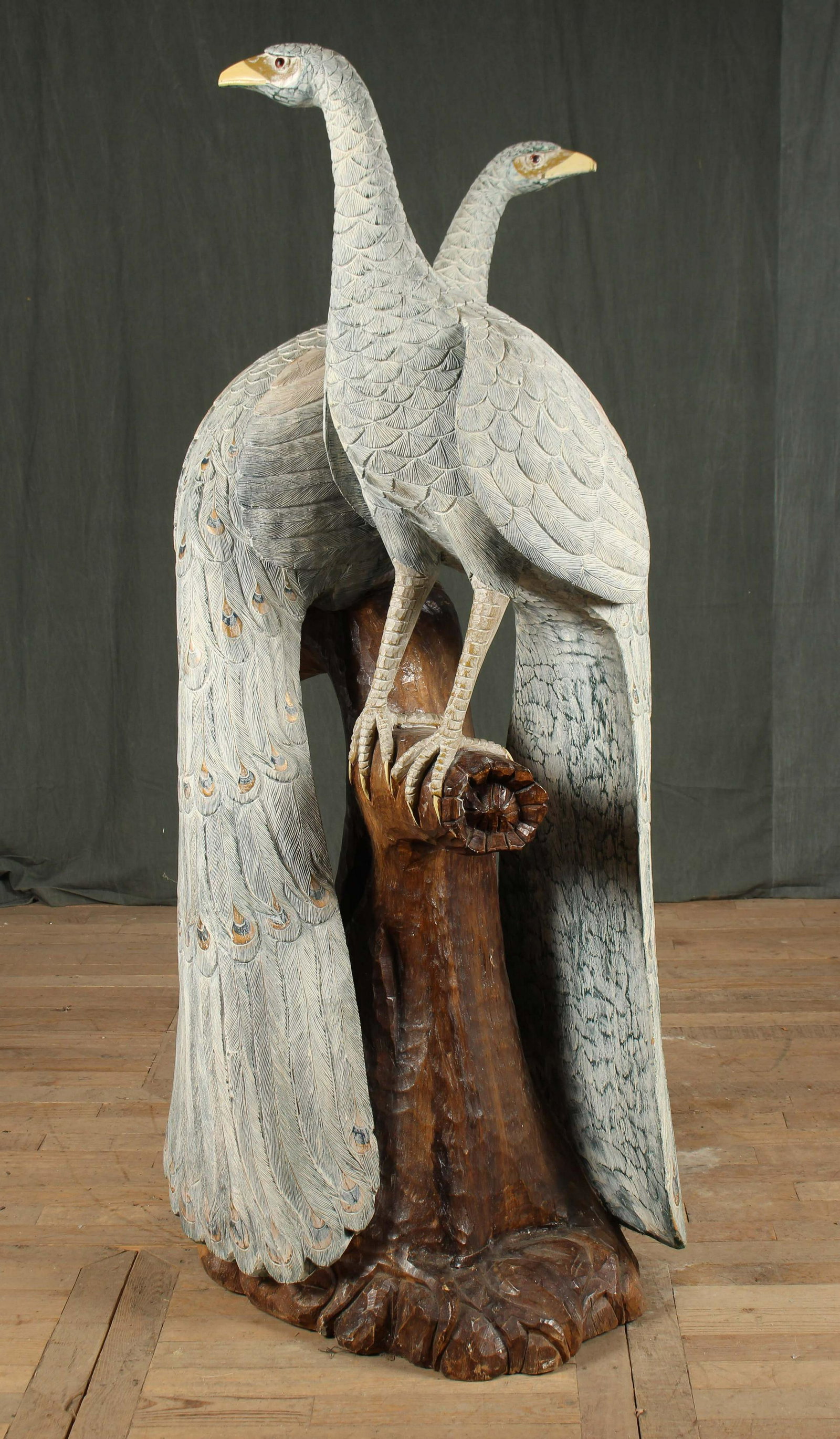 Monumental Carved Wood Peacocks: A monumental pair of carved wood peacocks each perching in the same tree. Both birds having detailed feather carving and paint decoration. Size: 71.5"H x 32"W x 29"D