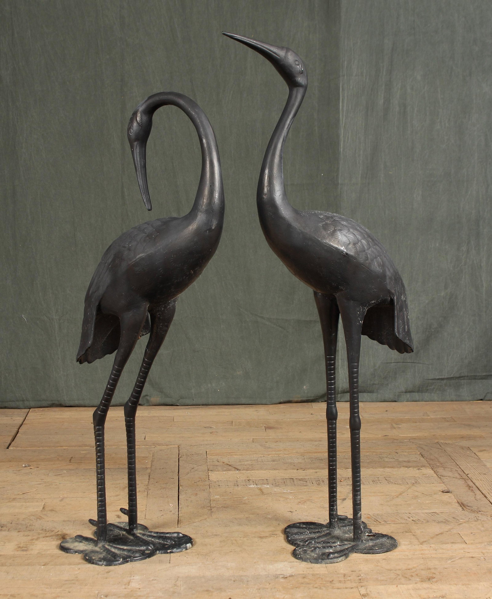 Cast Metal Herons: A pair of cast metal standing herons both with upraised heads. Size: 43"H x 10"W x 16"D