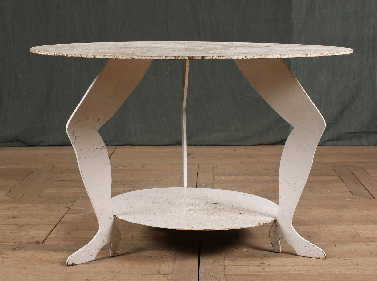 20th C Folk Art Garden Table: Interesting 20th Century Folk Art metal garden table with a round top supported on shaped leg form base with lower tier shelf. Size: 26"H x 41"Dia.