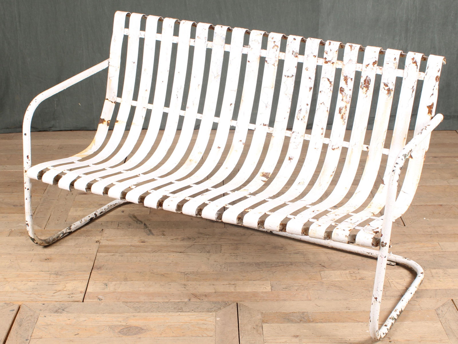Metal Strap Work Patio Bench: An early to mid 20th century strap work garden bench having open arms. Size: 34"H x 56.5"W x 28"D