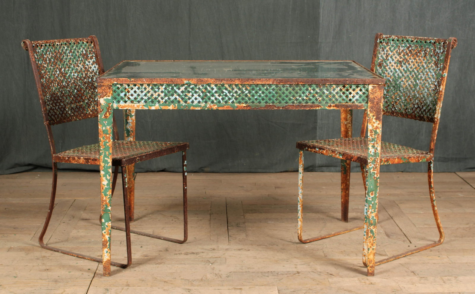French Wrought Iron Patio Set: A good French 1940's iron garden set consisting of a table and a pair of chairs all having woven trellis decoration. Size: table 29"H x 40"W x 28"D chairs 34"H x 15.5"W x 19.5"D