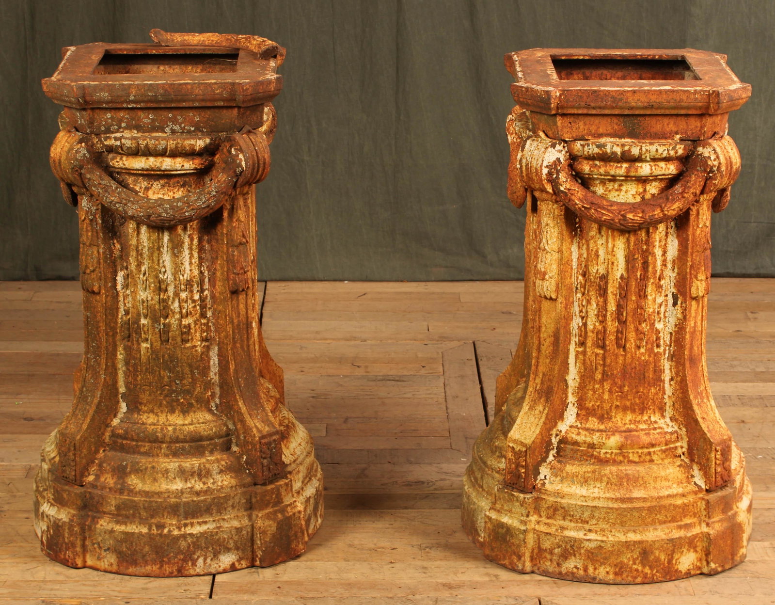 Pair Large Cast Iron Neoclassical Style Pedestals: A pair of large neoclassical cast iron pedestals each having draped garland and fluted columns above a stepped base. Size: 33"H x 20"Dia.