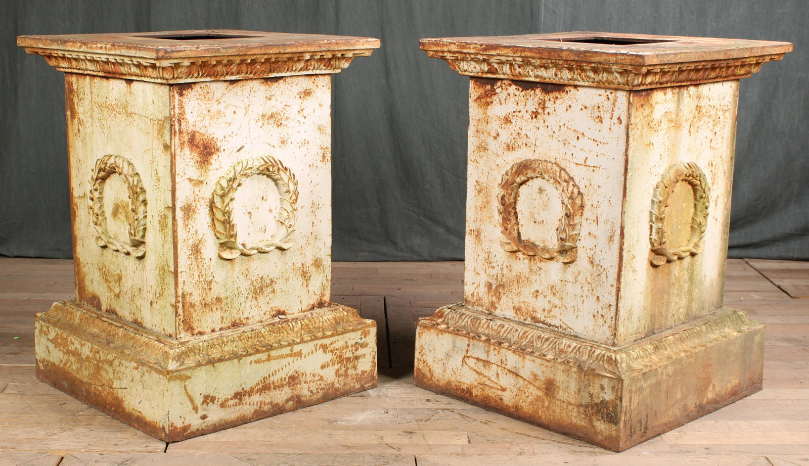 Grand Pair of Cast Iron Pedestal Bases: A monumental pair of neoclassical cast iron pedestals each having gadrooned upper frieze above garland wreath decorations. Size: 34"H x 25"W x 25"D