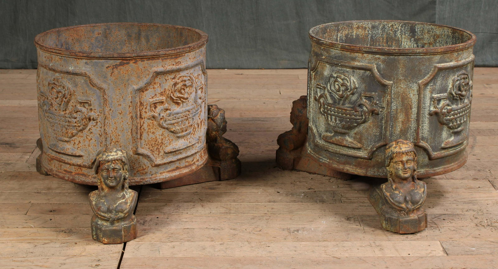 2 Regency Style Cast Iron Urns on Figural Feet: A pair of Regency style cast iron garden urns each having decorated panels and figural feet. Size: 13.5"H x 16"Dia.