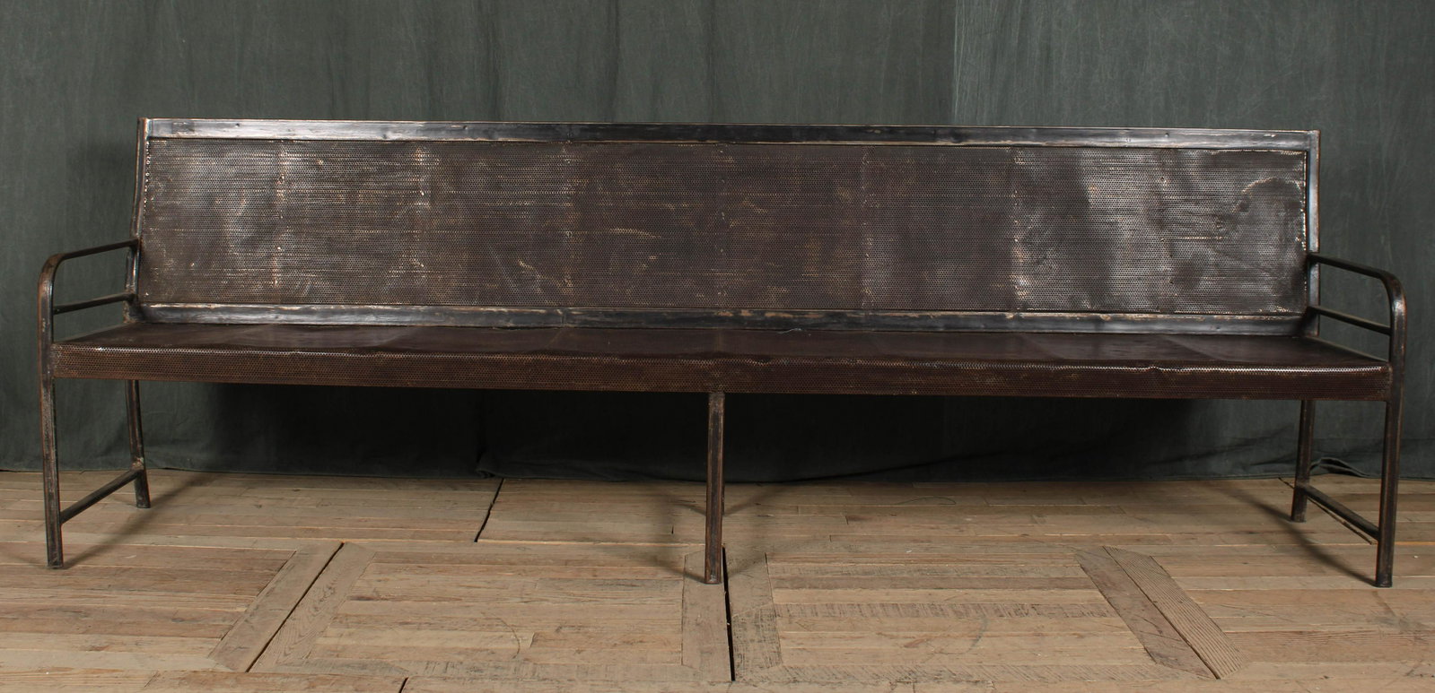 Modernist Metal Station Bench: A good metal modernist bench having metal mesh back and seat and open arms. Size: 33"H x 100"W x 19"D