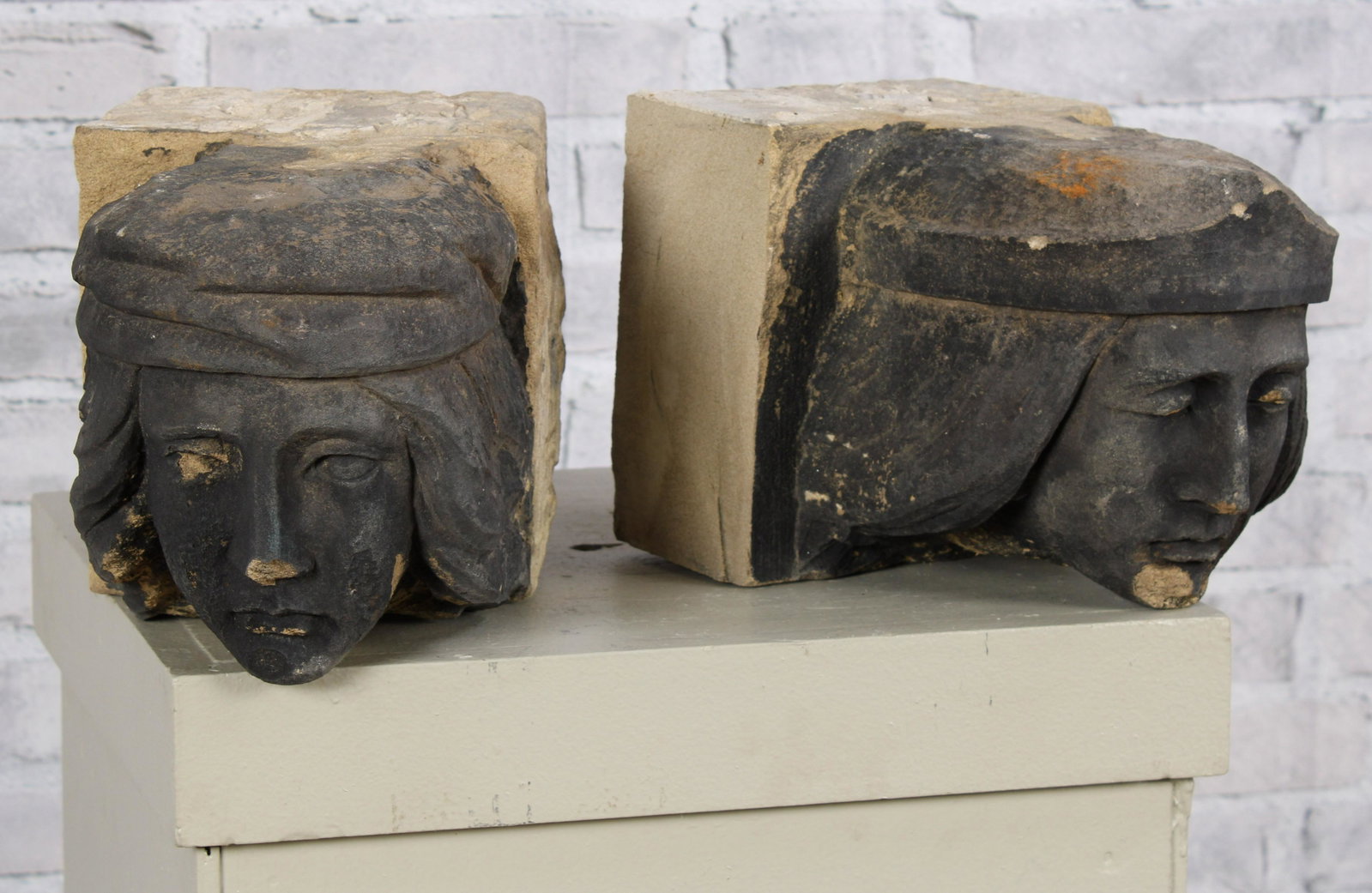 Antique Carved Stone Corbels: A good pair of 19th Century or earlier carved stone figural corbels each with a bust of a man in a stocking cap. Left Measured: H 7.5" x W 7.5" x D 11.5" Right Measured: H 7.5" x W 7.5" x D 10.5"