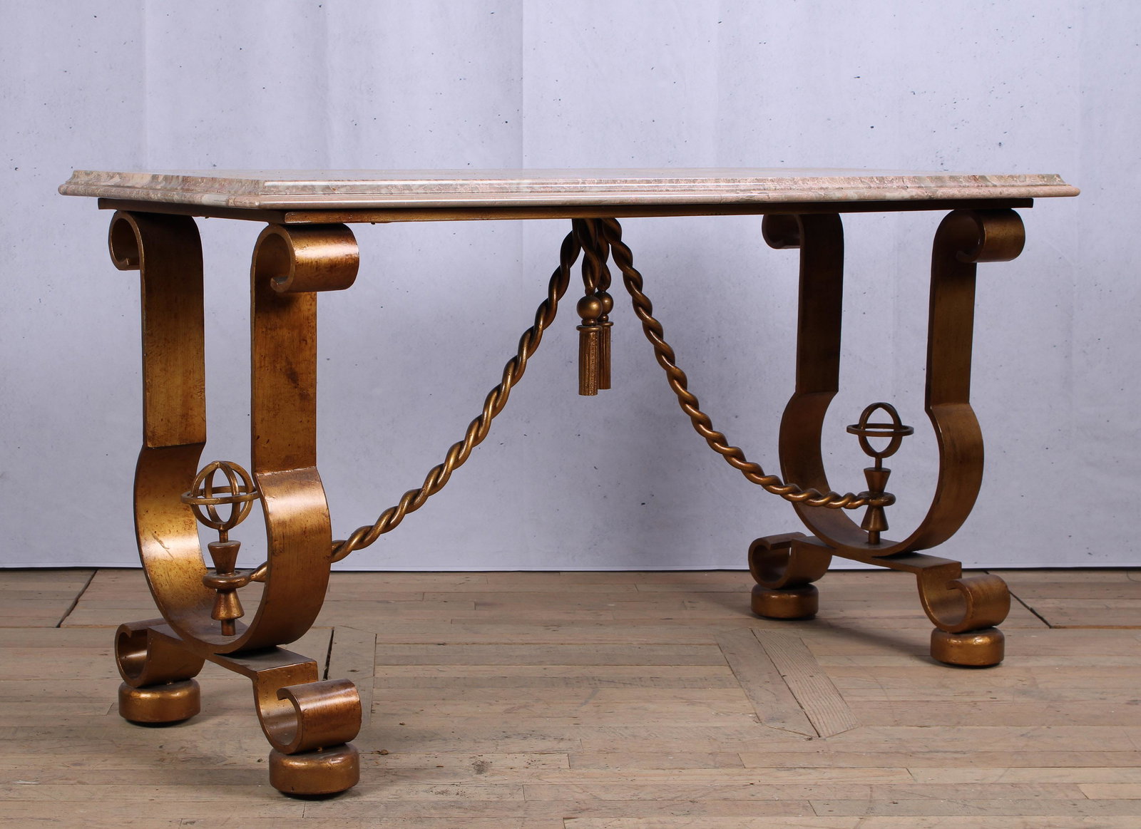 Andre Arbus Style Console Table: A good Andre Arbus style gilt decorated console table having a marble top supported on urn shaped base with twist form stretcher and drop tassels. Size: 33.5"H x 61"W x 25"D