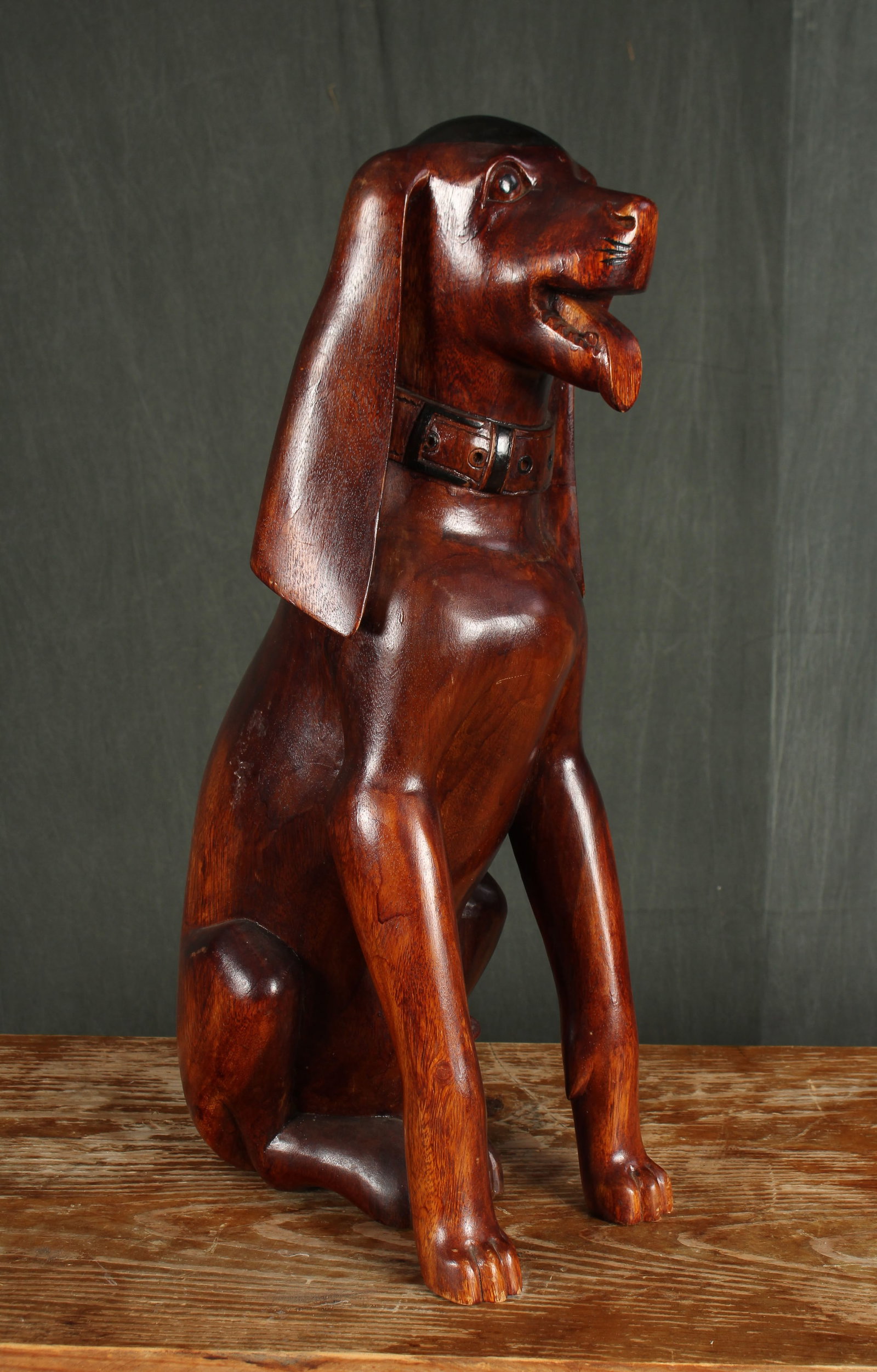 Folk Art Carved Wood Dog: A vintage Folk Art carved wood seated dog with long ears and open mouth. Size: 25.5"H x 8"W x 12"D