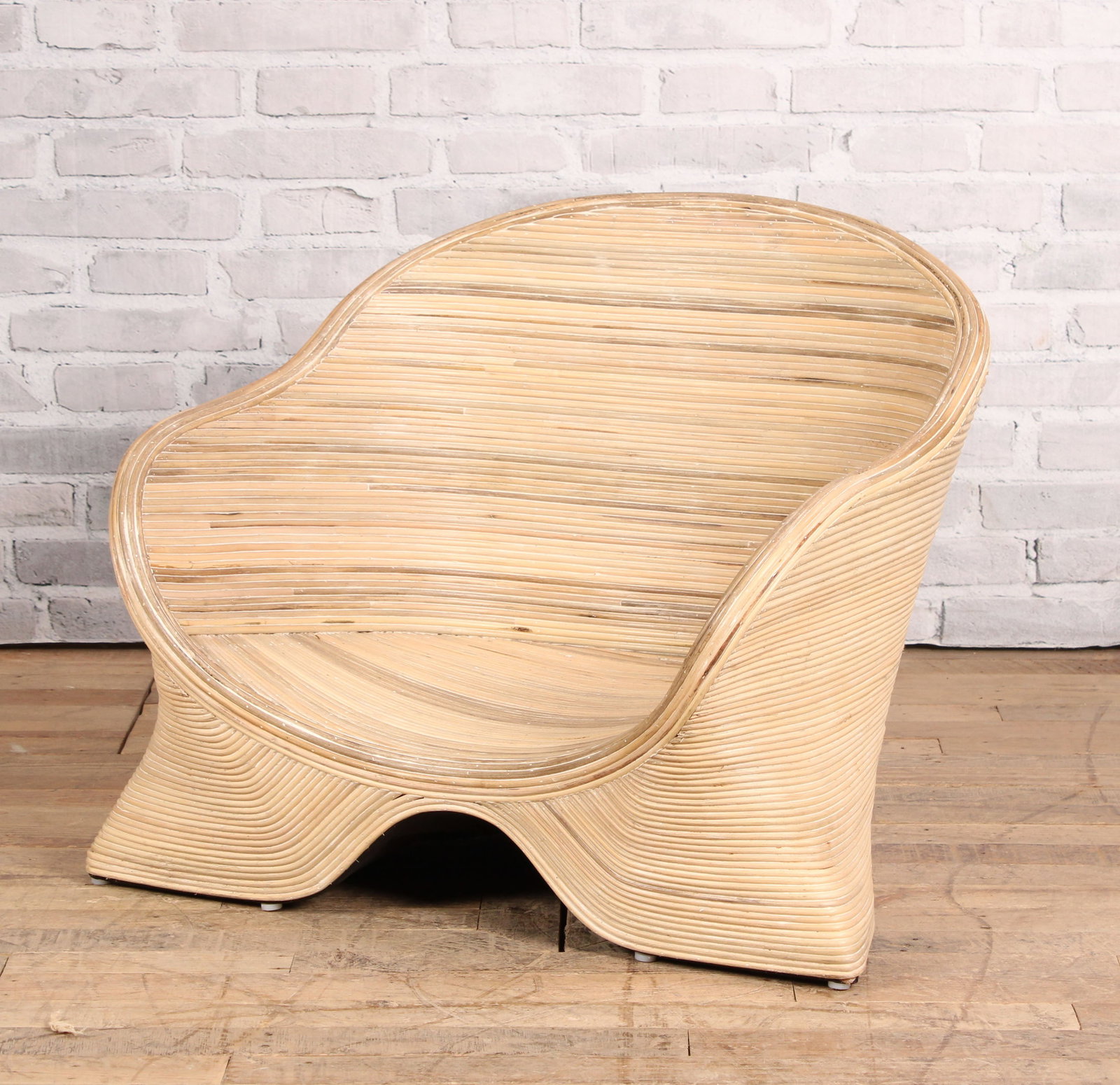 Pencil Reed Low Slung Deck Chair: A stylish Pencil Reed club chair or low lounge chair having barrel back and flared arms. IMO Betty Cobunpue. Size: 25.5" H x 30" W x 28" D