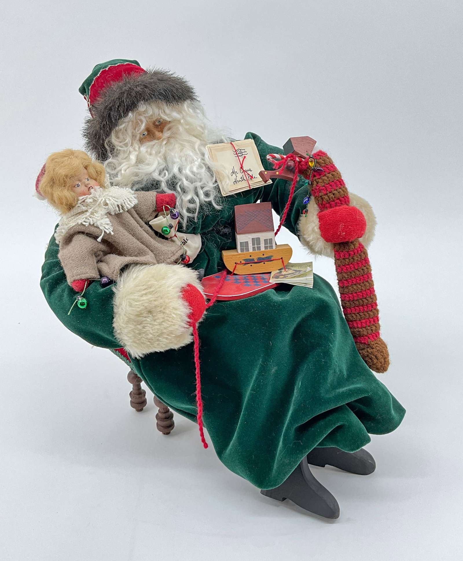 Green Velvet Santa With Toys: Santa decked out in a luscious green velvet robe, seated on a bench with a nice selection of toys. From Ye Olde Santa Maker. From a single owner collection, PA estate, stored in a glass cabinet. Size: