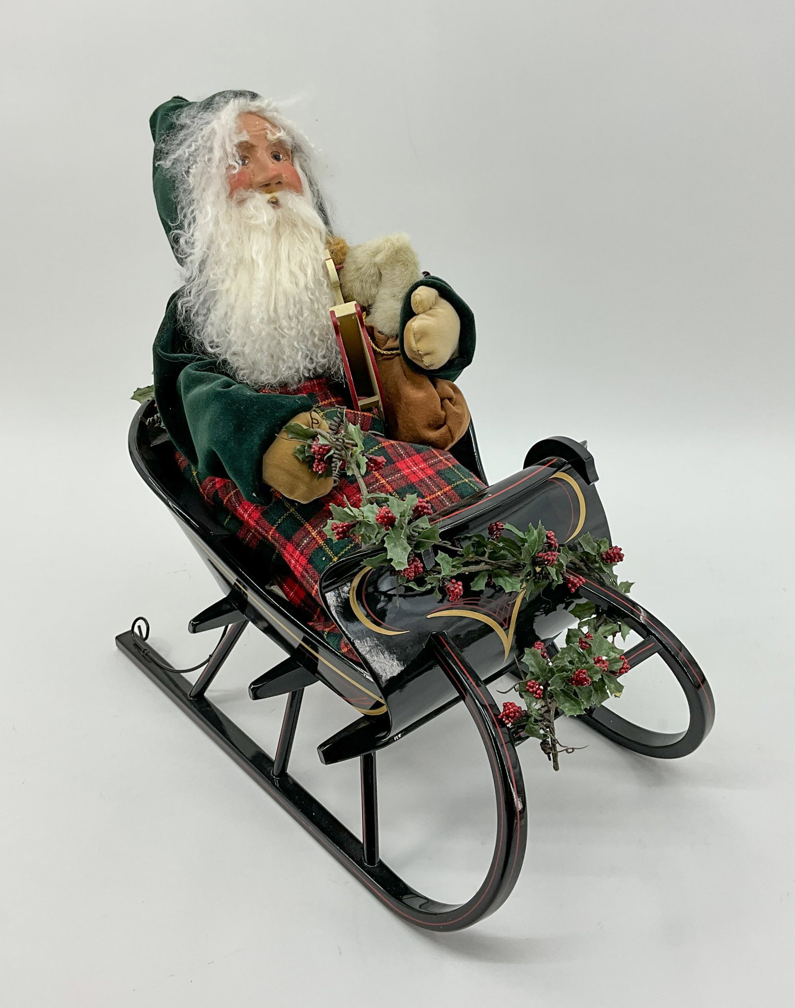Cozy Santa in His Sleigh: Santa is dressed in green and all bundled up in his metal slay. From a single owner collection, PA estate, stored in a glass cabinet. Size: H 19" x W 11" x D 19" Shipping Note: For your convenience, w