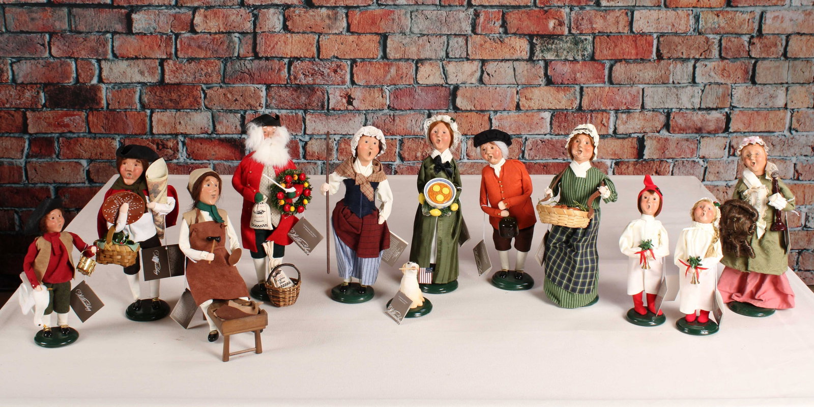 Williamsburg Caroler Collection, Byer's Choice: A selection of 12 figures from the Byer's Choice Williamsburg collection. See photos for dates. From a single owner collection, PA estate, stored in a box. Size: approximately 14"T x 5" diameter Shipp