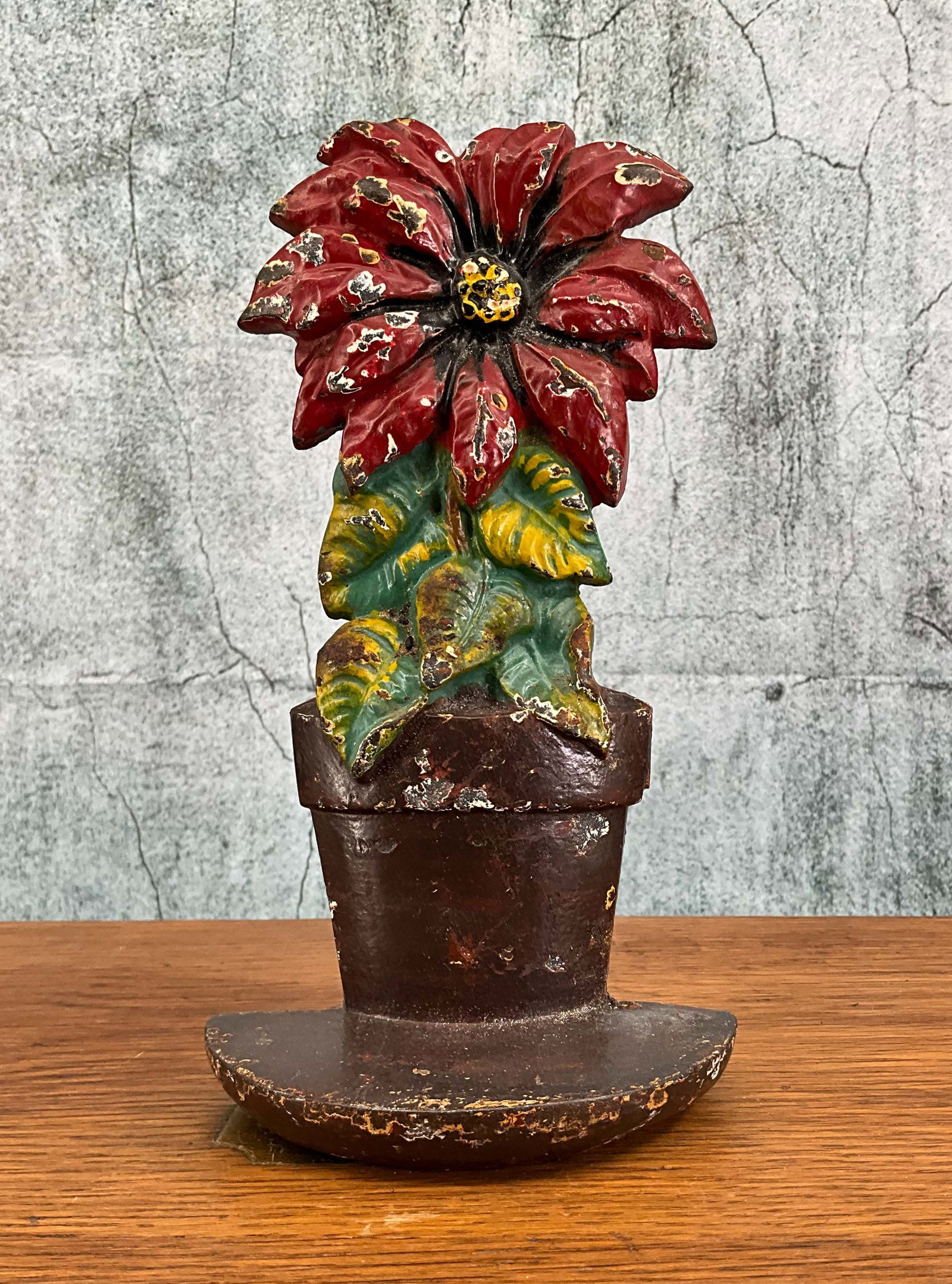 Poinsettia Cast Iron Doorstop, Hubley: Cast Iron poinsettia doorstop by Hubley, original paint, single piece flat back with hollow form. Provenance: Single owner collection, suburban Philadelphia estate. Size: 9"T Shipping Note: For your c