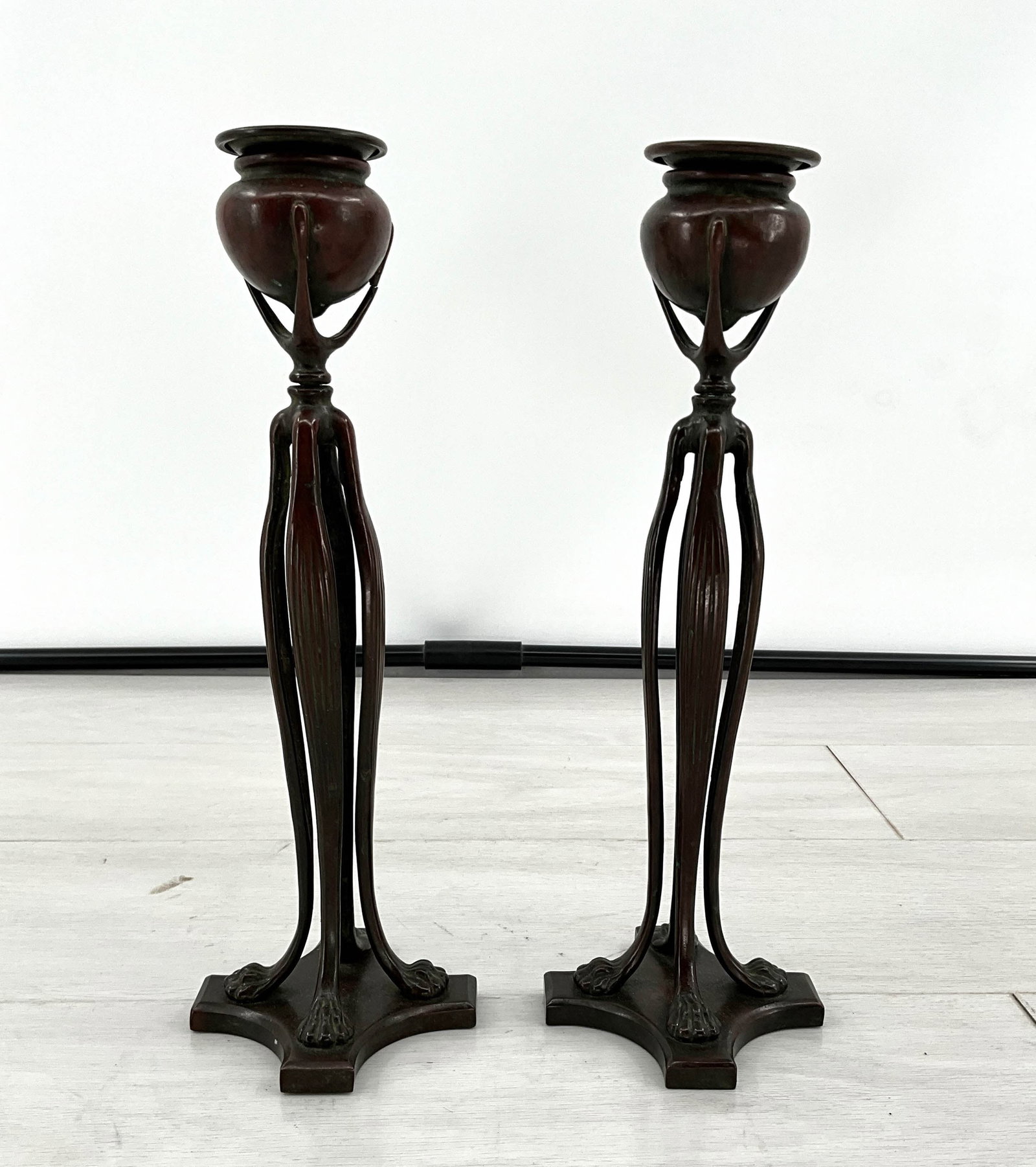 Pair Tiffany Style Candle Sticks With Claw Feet: Pair of bronze candle sticks with claw foot details. Tiffany Style. Size: 11"H on a 4"W x 4"D base