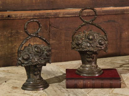 Pair Cast Iron Floral Door Stops: Hubley style cast iron doorstop pair, floral basket motif. Size: 12"T x 7"W x 2.5"D. Books not included.