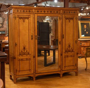 English Satin Wood Three Door Wardrobe: A very stylish English 19th Century Edwardian Satinwood and mahogany inlaid three door dressing cabinet having central mirrored door flanked by two elegant inlaid doors framed by pilasters. Size: 85.5