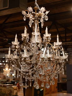 French Crystal Chandelier: Ornate French crystal chandelier with tiered lights and floral details. Size: 55"T x 42" diameter Circa: 1890 List Price: $19500