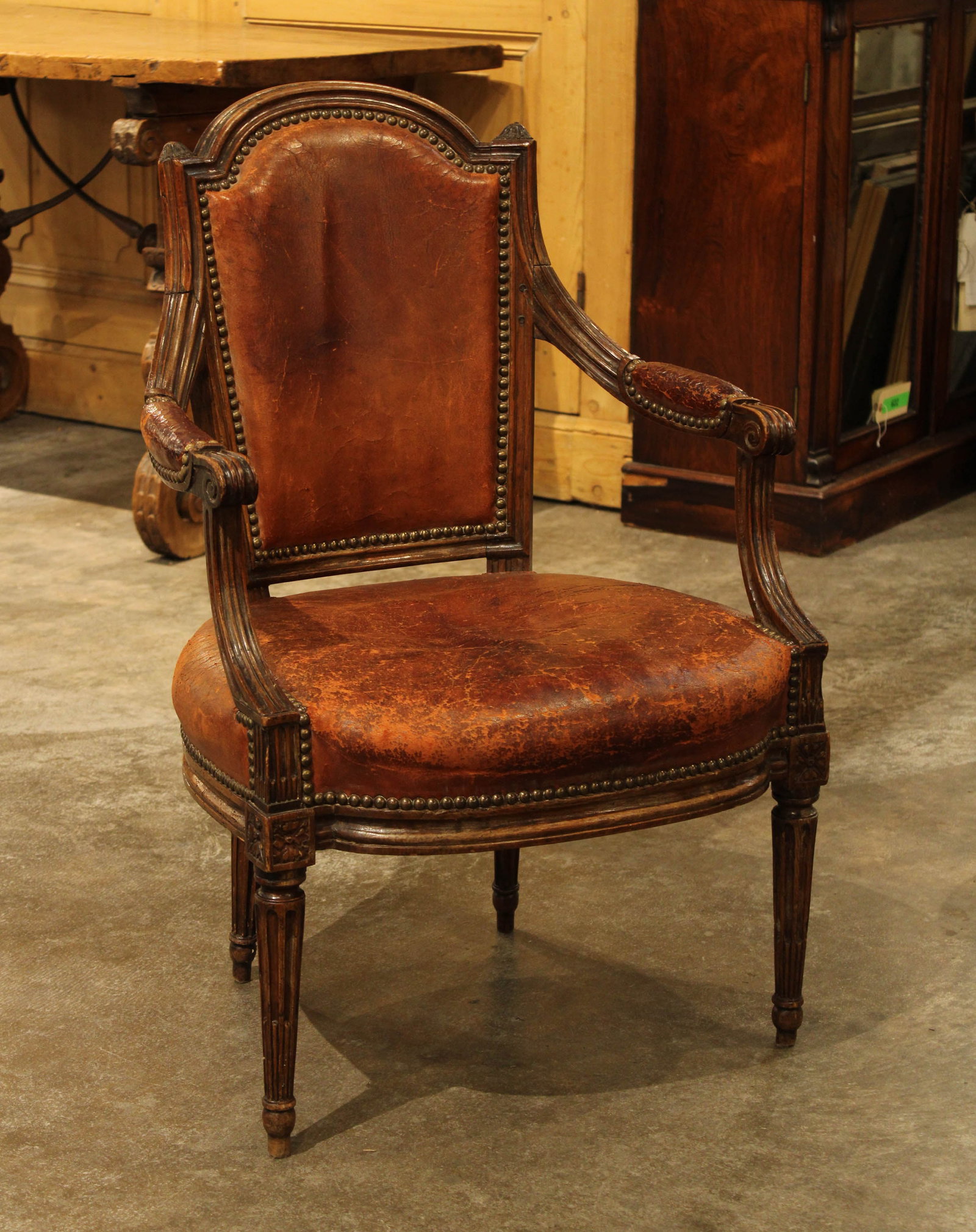 Continental Leather Fauteuil, Louis XVI Style: A late 19th Century French Louis XVI style leather upholstered armchair with nail head trim. Size: 35.5"H x23"W x18"D seat height 16" Circa: 1900 List Price: $4900