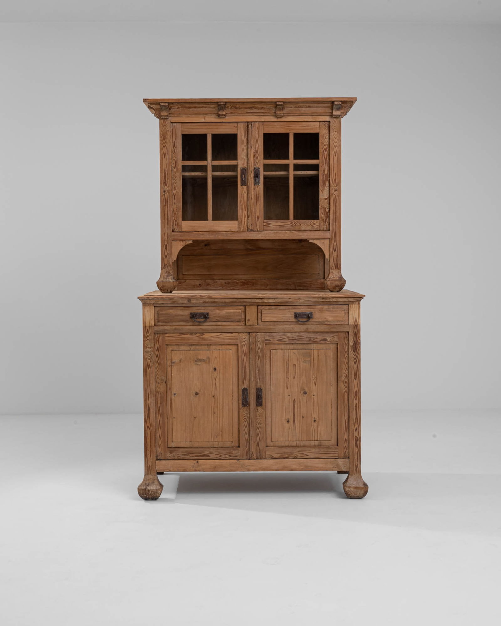 Transitional French Art Nouveau Cupboard: French cabinet, stepped cornice on top with paned glass front doors on top, 2 drawers and two solid doors underneath. Middle supports and feet have a coordinating sculpted design. Comes with key. Dime