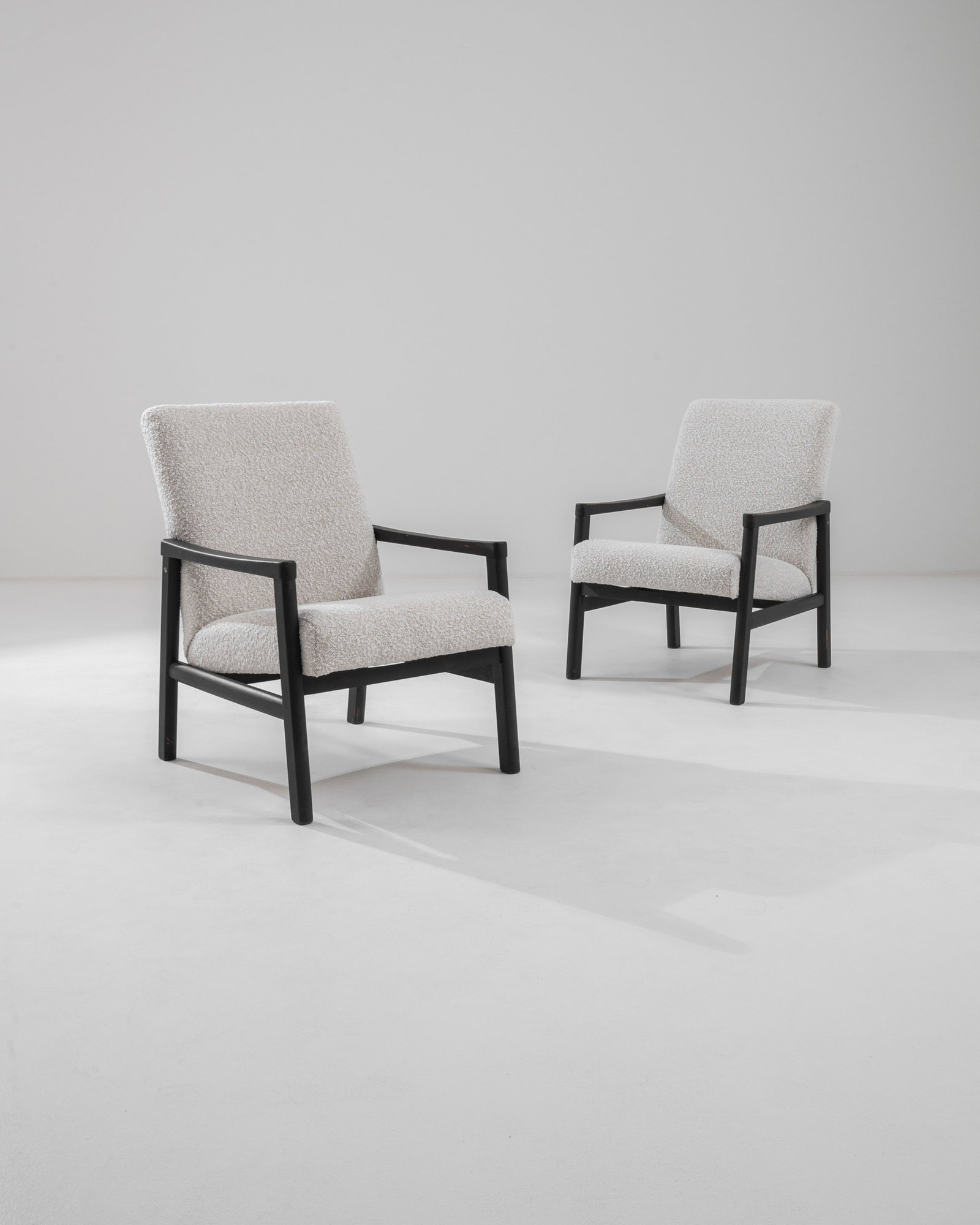 Czech Designl Mid Century Armchairs: European modern pair of arm chairs, black distressed frames with cream boucle upholstery. Dimensions: H 30.75" x W 22" x D 23.50" Origin: Mid 20th Century, Czechia** Please Note: All items are located
