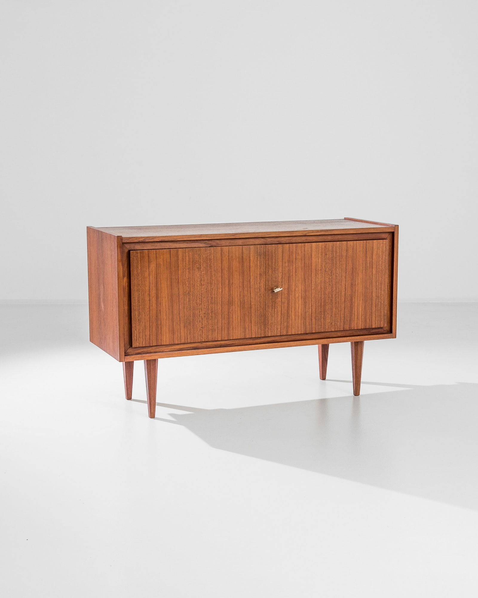 Modernist German Credenza, Server: MCM German made lowboy, 2 doors on tapered legs, original makers tag still attached. Dimensions: H 28.50" x W 47.25" x D 17.50" Origin: Germany, 1960** Please Note: All items are located in High Point