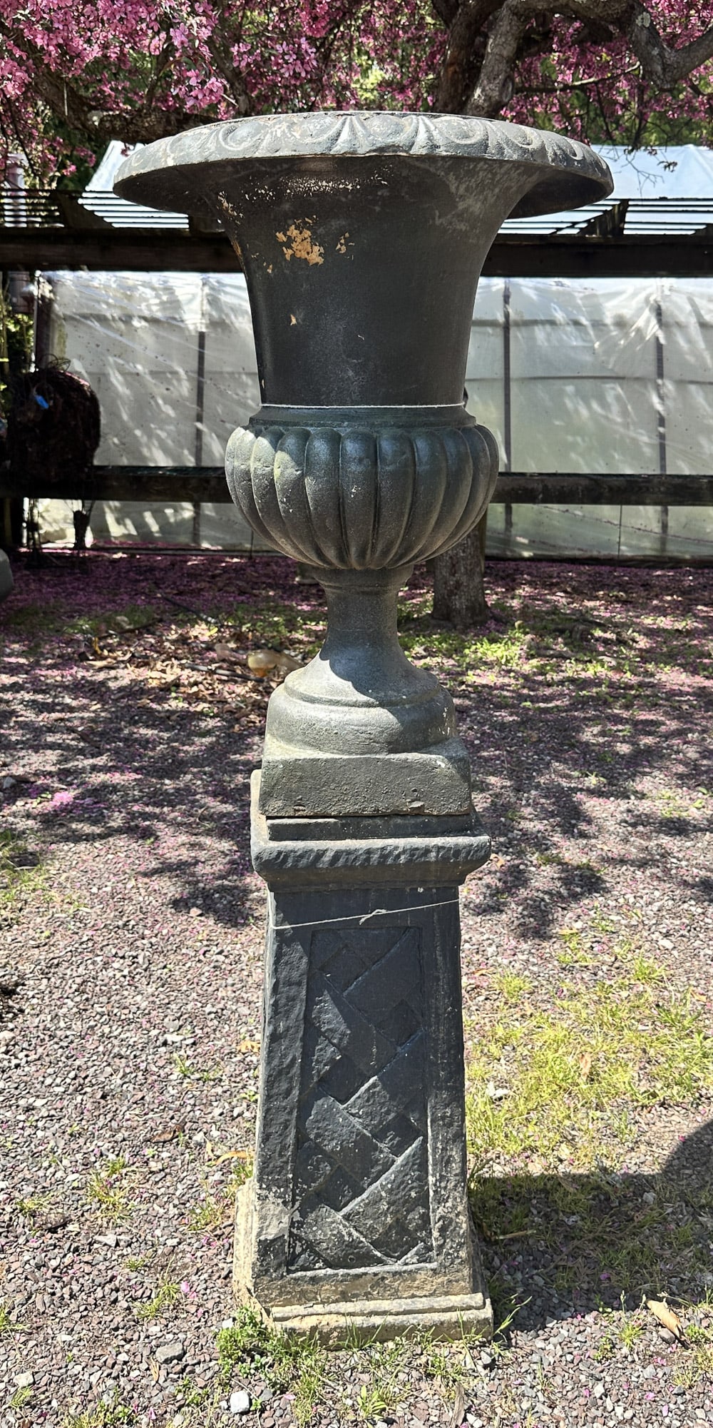 Cast Iron Urn On Basket Weave Pedestal: Campaign style cast iron urn on a basket weave pedestal base. Some damage to base as seen in photos. Size: 57.5"t x 23" diameter