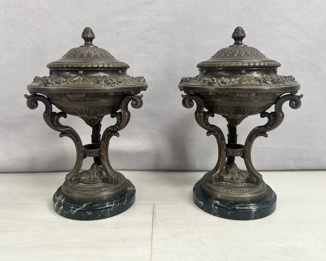 Pair of Spelter Censors On Marble Bases: Spelter censors with bronze colored finish on marble bases, scroll work and floral motif. Stamped Made in France. Grand tour style. Size: 10.5"T x 6.5" diameter