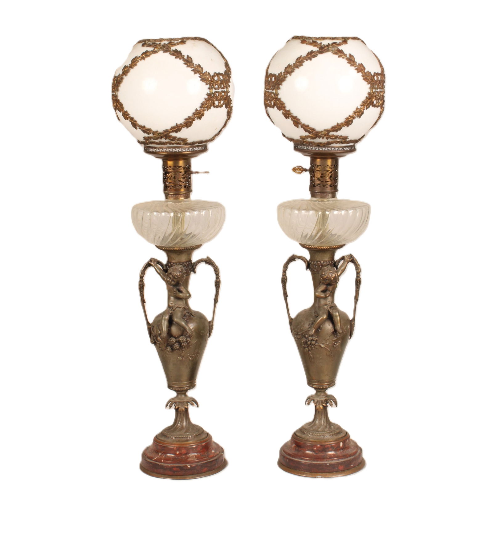 Antique Bronze lamps: Victorian era oil lamps converted to electric, bronze amphora shaped base with puttis and large white and gold glass globes. Untested. Size: W/globe 30.25"H x 6.5"W x 6"D w/out 23.5"H