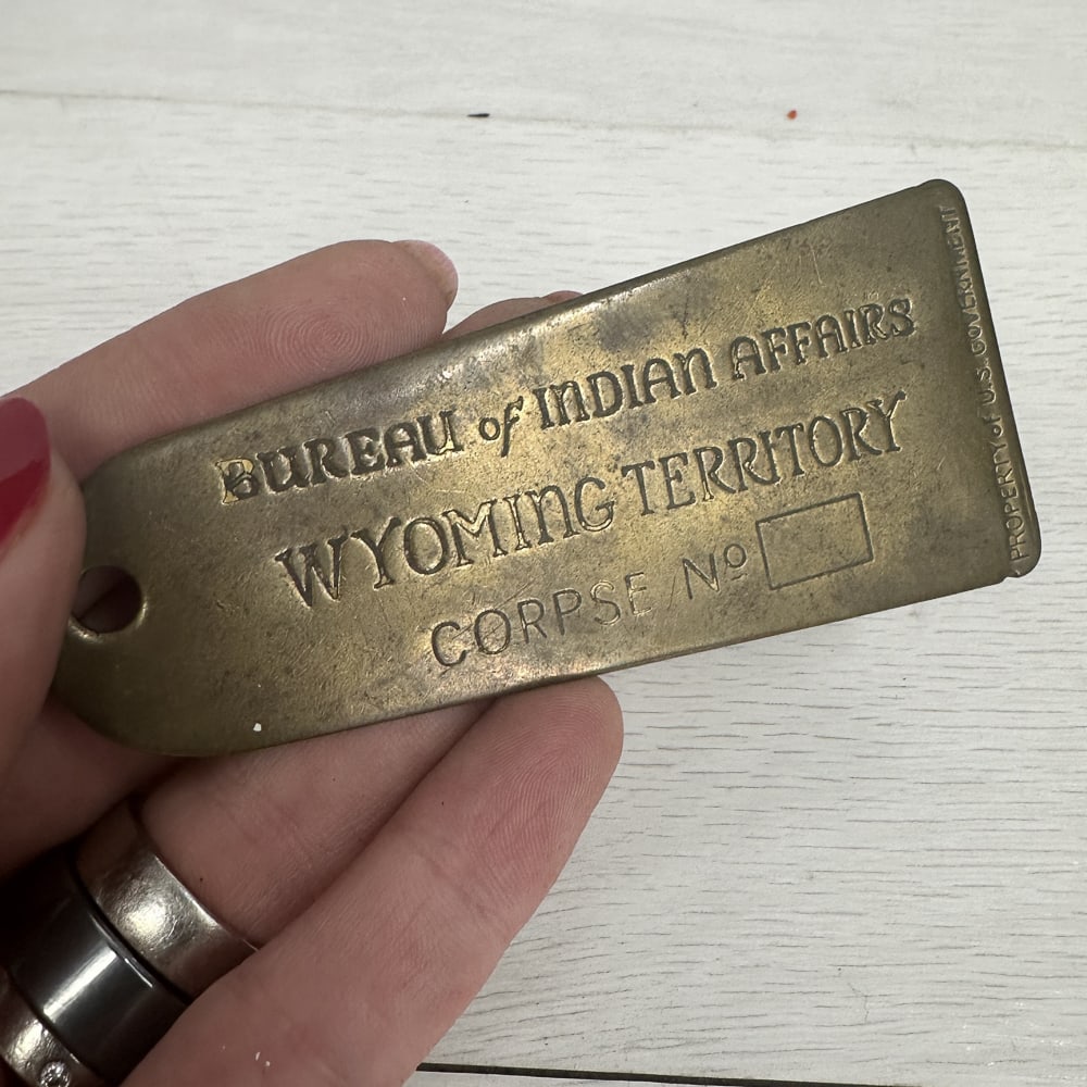 Indian Affairs Toe Tag, Wyoming: A very interesting and slightly morbid piece of Americana. A brass toe tag reading "Bureau of Indian Affairs, Wyoming Territory, Corpse No. ____. " "Property of US Government" down the side. Size: 3.5