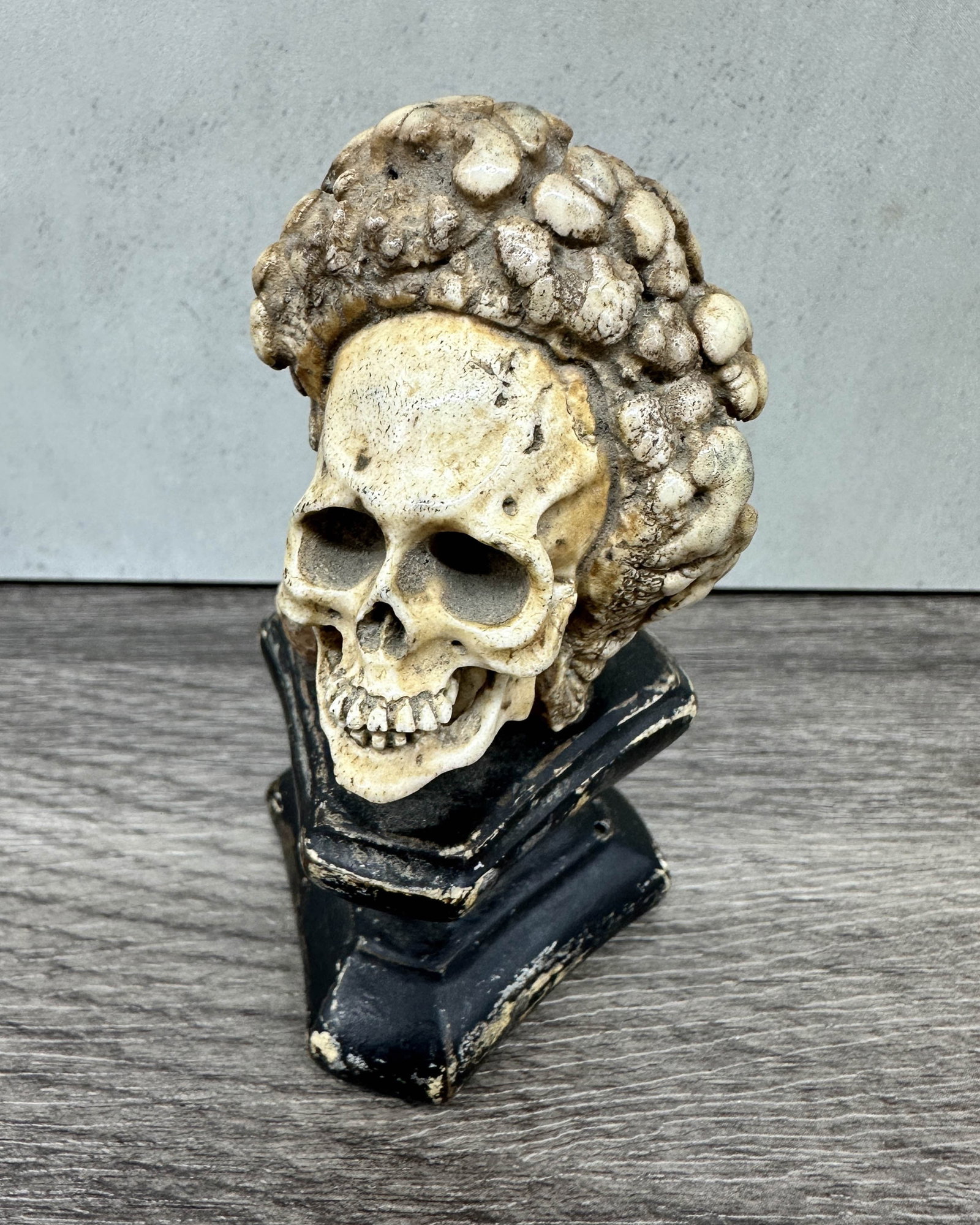 Memento Mori Skull On Stand, Bone: Continental style carved bone memento mori skull on carved wood plinth. Size: 3.5"T x 2"L x 2"D