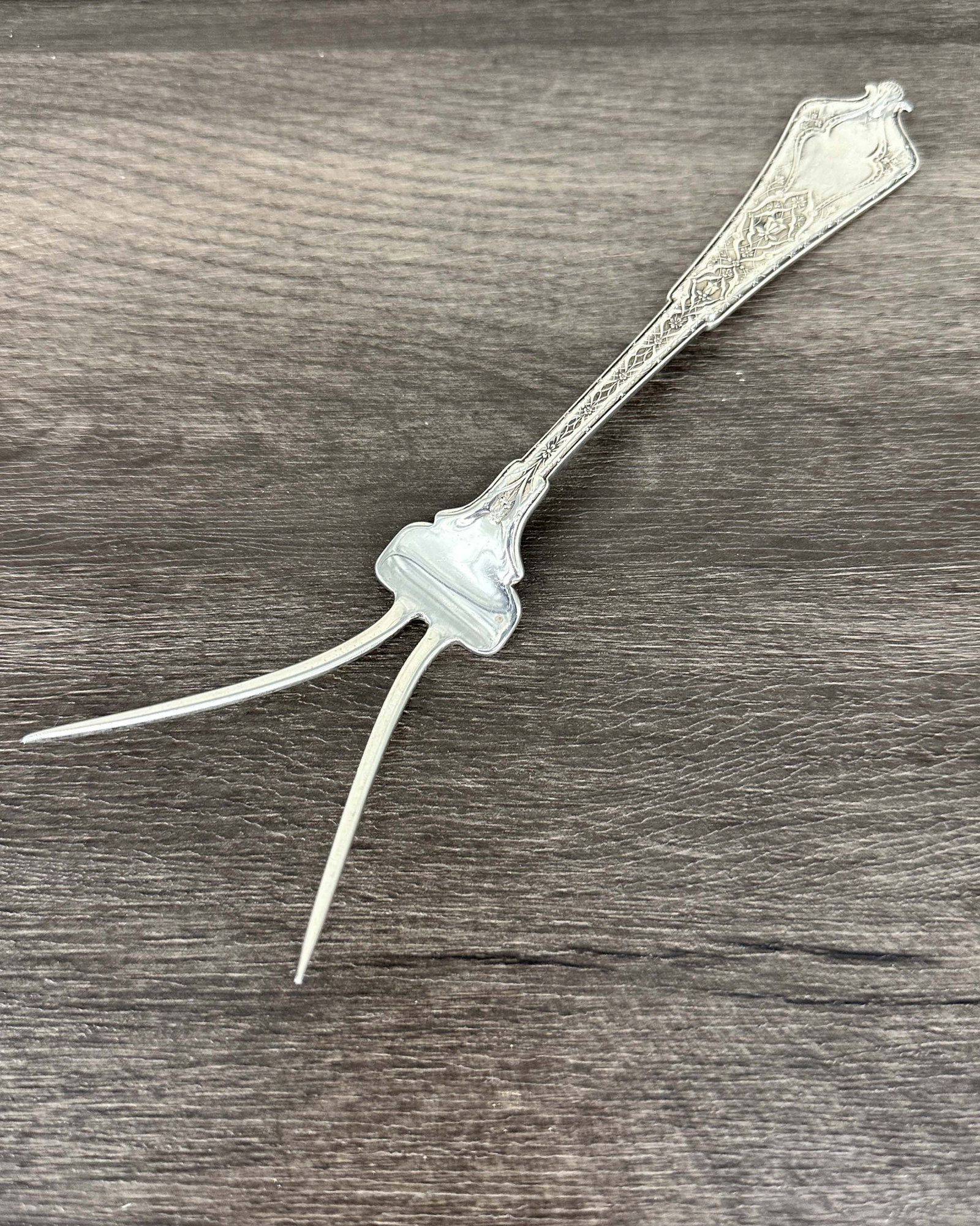 Tiffany Sterling Silver Service Fork: A serving fork by Tiffany, stamped on back and dated 1893. Persian Pattern. Size: 8"L